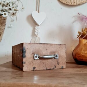 Assemblée à la façon d'un petit tiroir d'atelier, cette petite boîte possède une poignée en métal patinée.