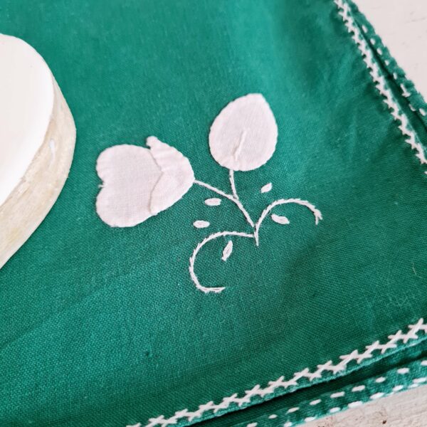Chaque serviette possède un motif floral brodé avec du fil de coton blanc.