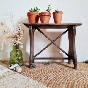 Banc de ferme ancien en bois avec piétement croisé et patine du temps