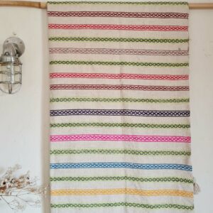 Plaid artisanal en coton tissé au Maroc avec pompons en laine