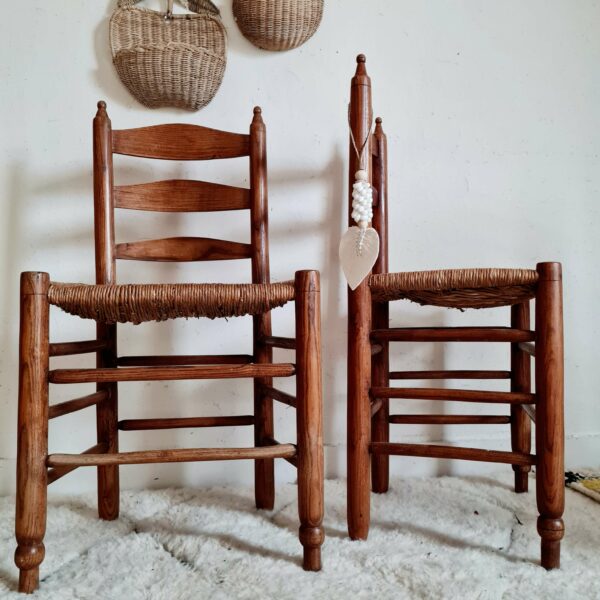 Ces chaises anciennes en bois et en paille affichent un look brutaliste pour réchauffer un intérieur avec authenticité.