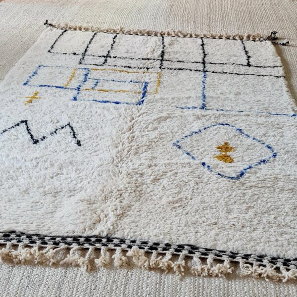 Finitions frangées tressées sur les deux faces pour ce tapis Beni Ouarain en laine de mouton