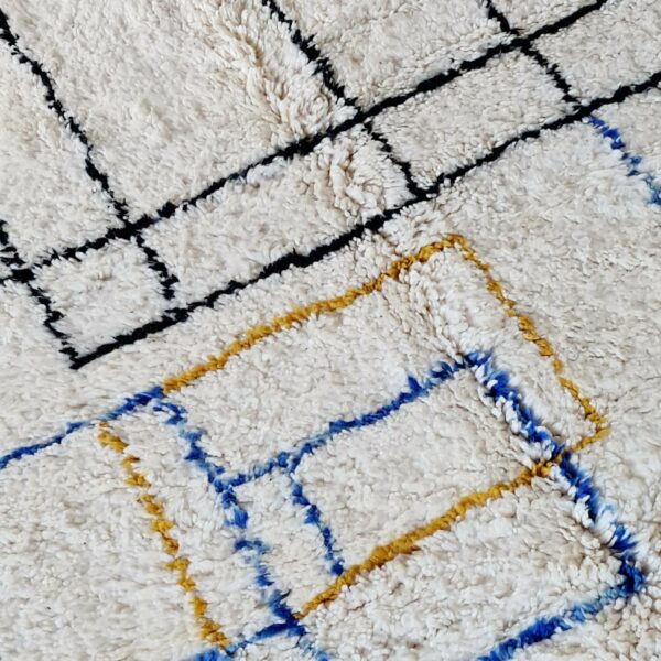Ce tapis berbère Beni Ouarain affiche des lignes graphiques bleues ocre et noires tel une œuvre d'art contemporaine