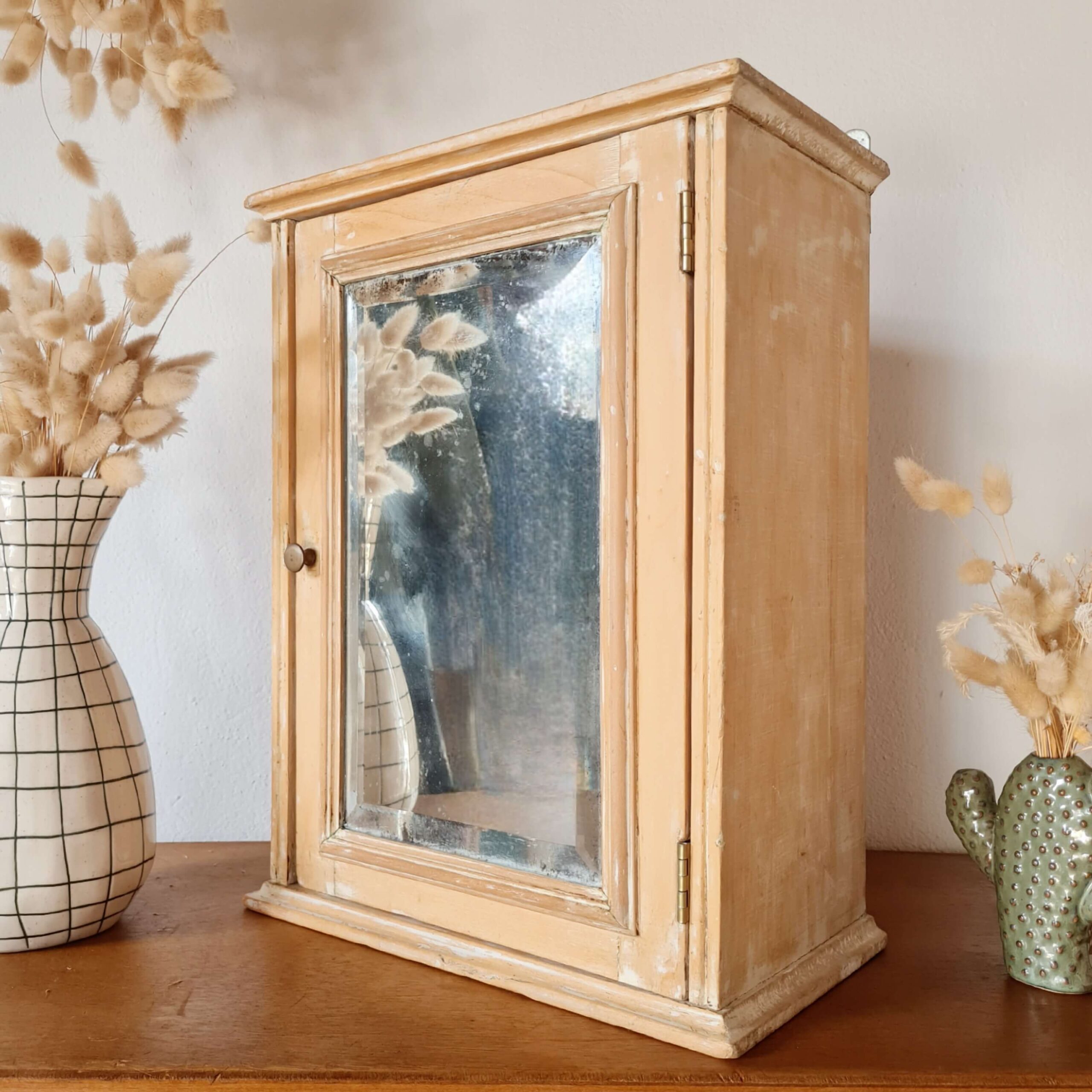 Vue de profil d'une petite armoire ancienne en bois avec son miroir