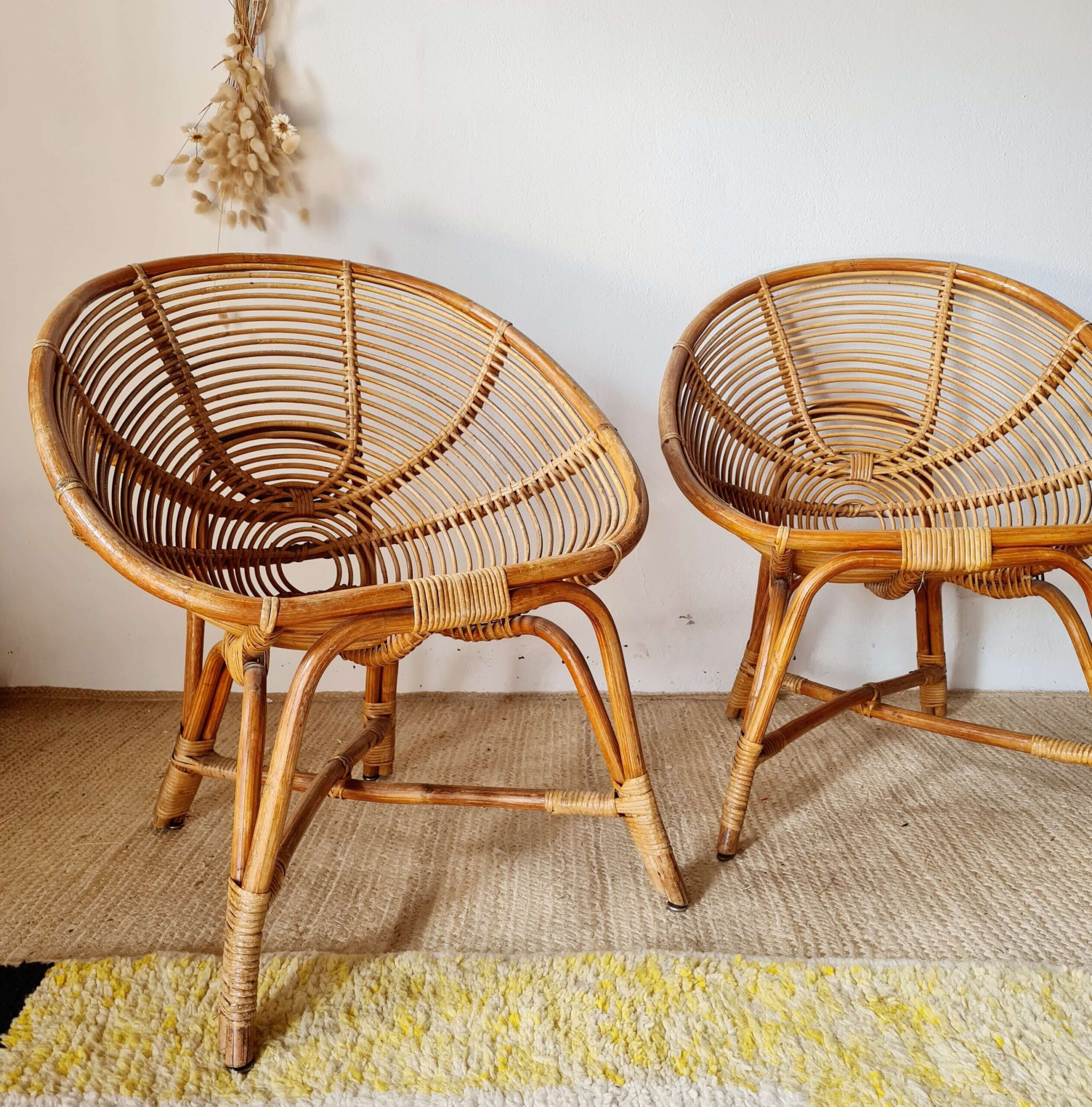 Vue d'ensemble de deux fauteuils en rotin de style bohème, mettant en valeur leur structure légère et leur finition en bois naturel