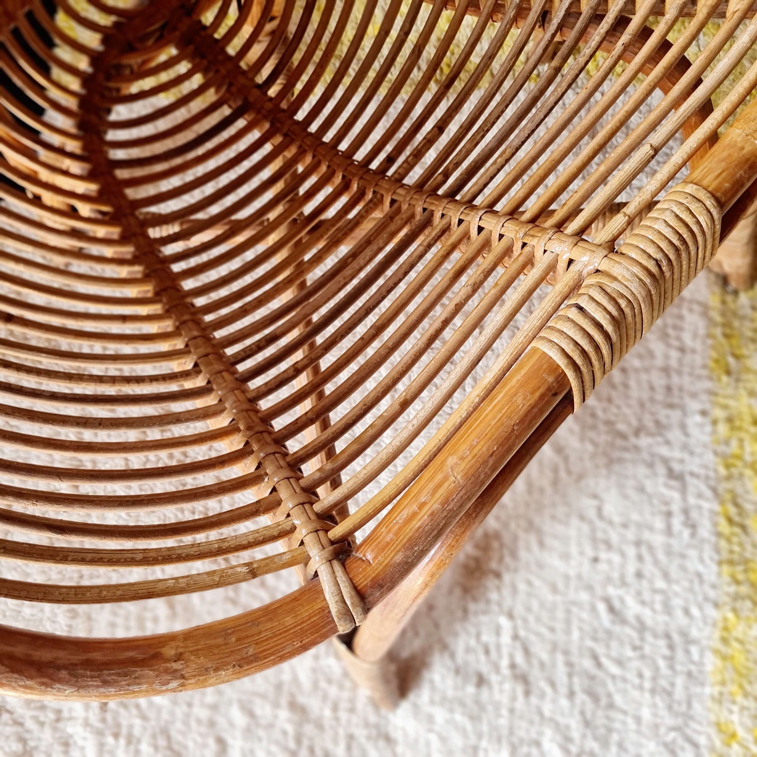 Gros plan sur le travail de tressage artisanal du rotin sur l'assise d'un fauteuil vintage, révélant la finesse des finitions