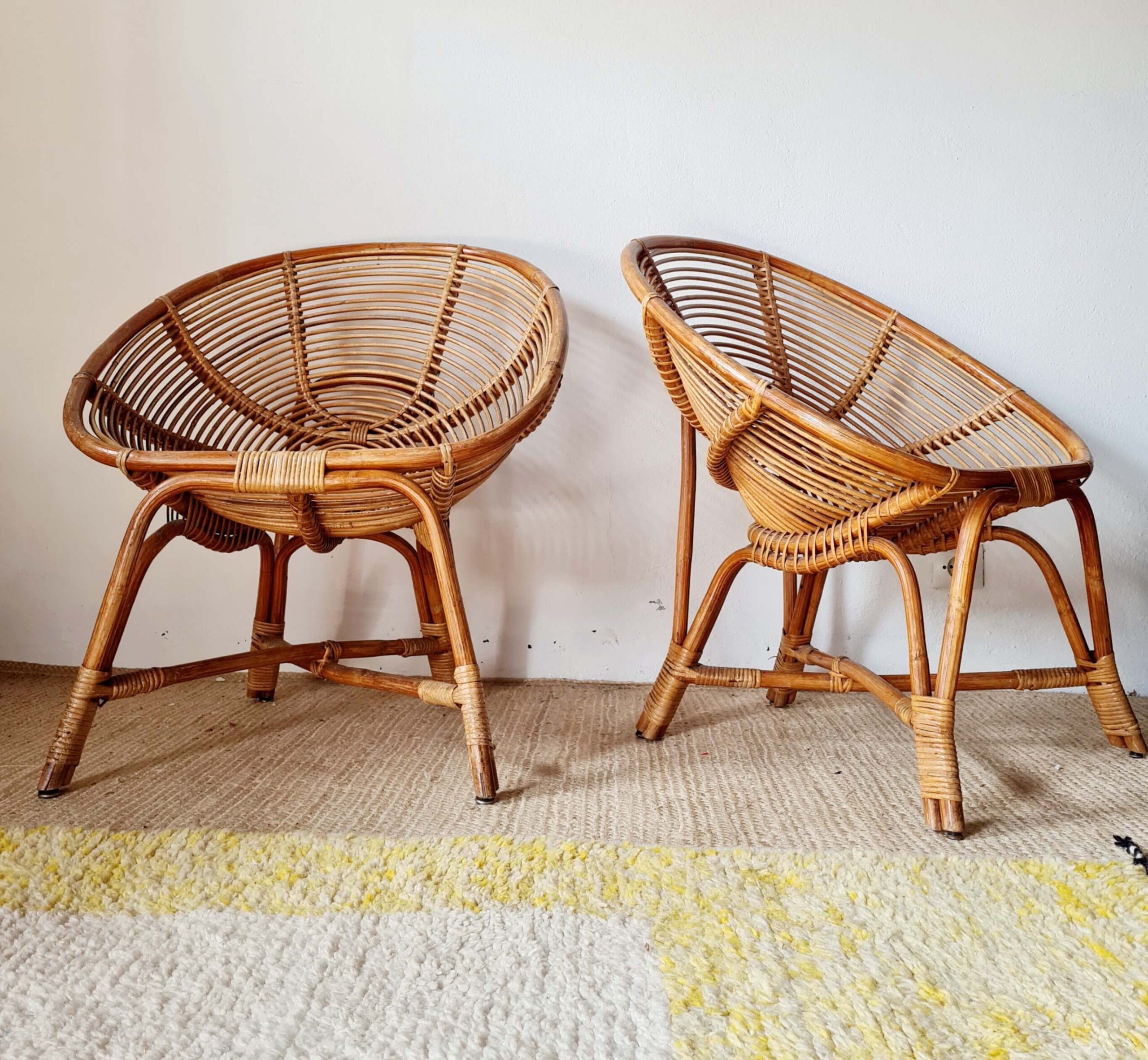 Paire de fauteuils vintage en rotin naturel de forme ronde, parfaits pour une ambiance bohème, vus de face sur un fond blanc