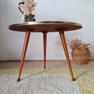 Autre vue de face de la table basse scandinave avec ses trois pieds compas fuselés et sa tranche en laiton brillant.