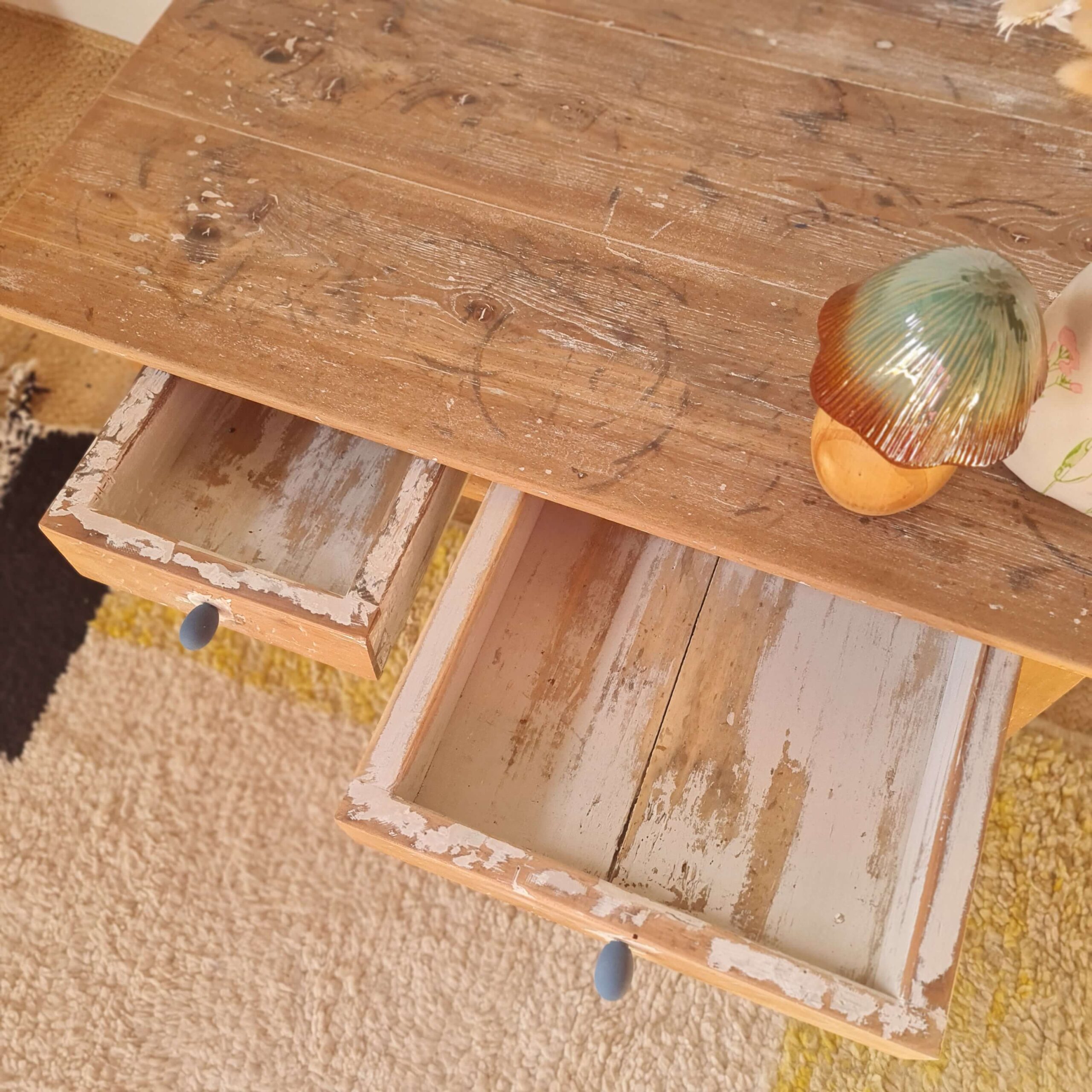 Vue en contre-plongée du plateau en bois brut d'une table basse ancienne avec un champignon décoratif