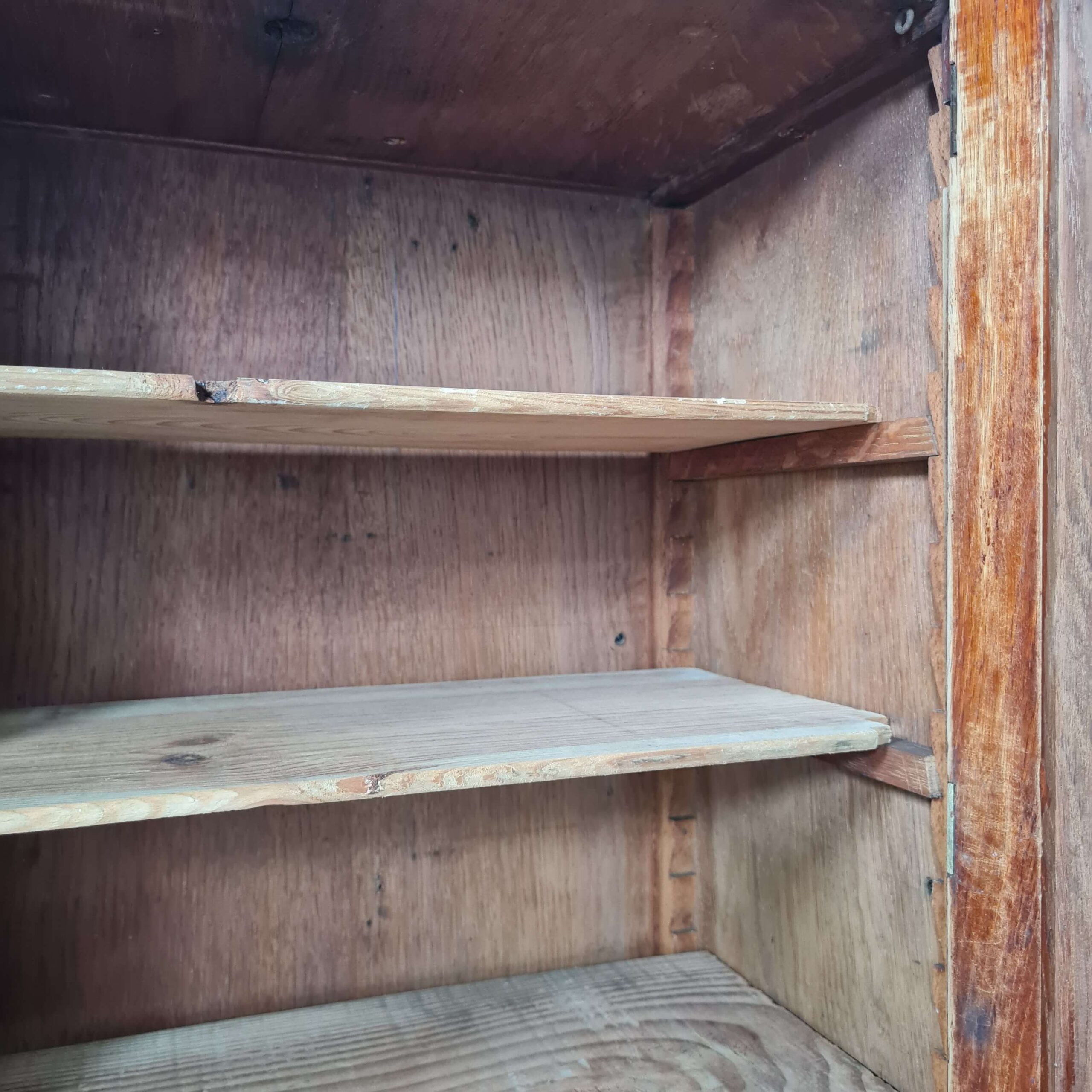 Gros plan sur le système de crémaillères en bois d'époque pour ajuster la hauteur des étagères d'une armoire de pharmacie