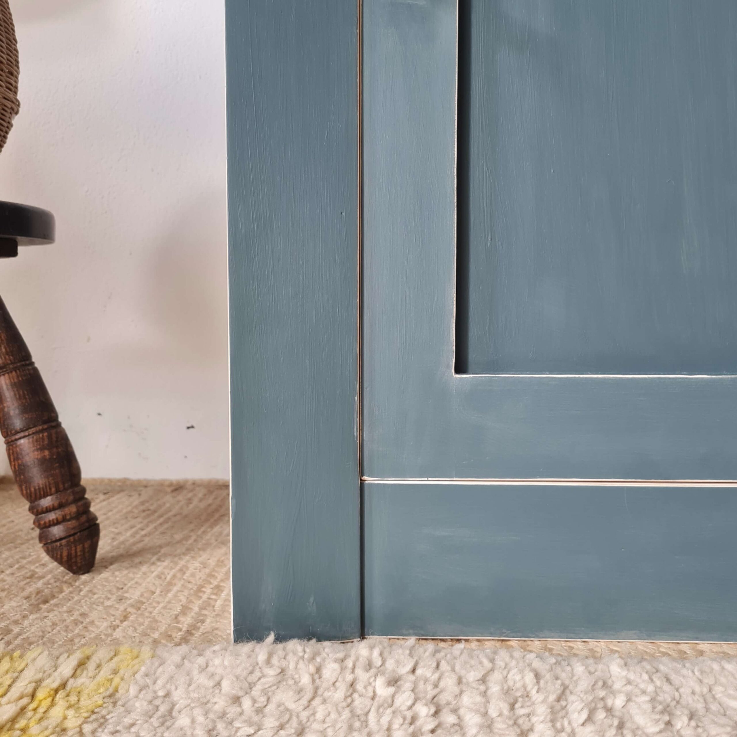 Détail de la finition d'une armoire ancienne peinte en bleu, montrant la qualité des joints et de la peinture