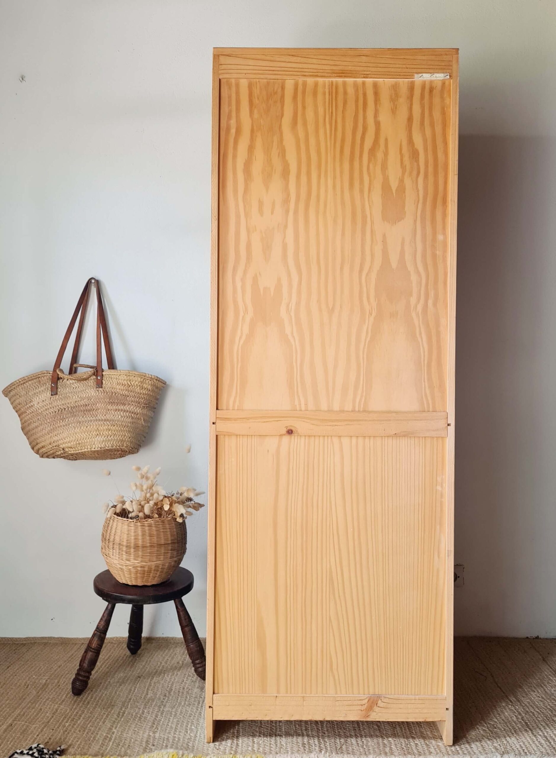 Vue arrière d'une armoire en bois brut, révélant la texture naturelle des veines du bois et la qualité de la structure du meuble.