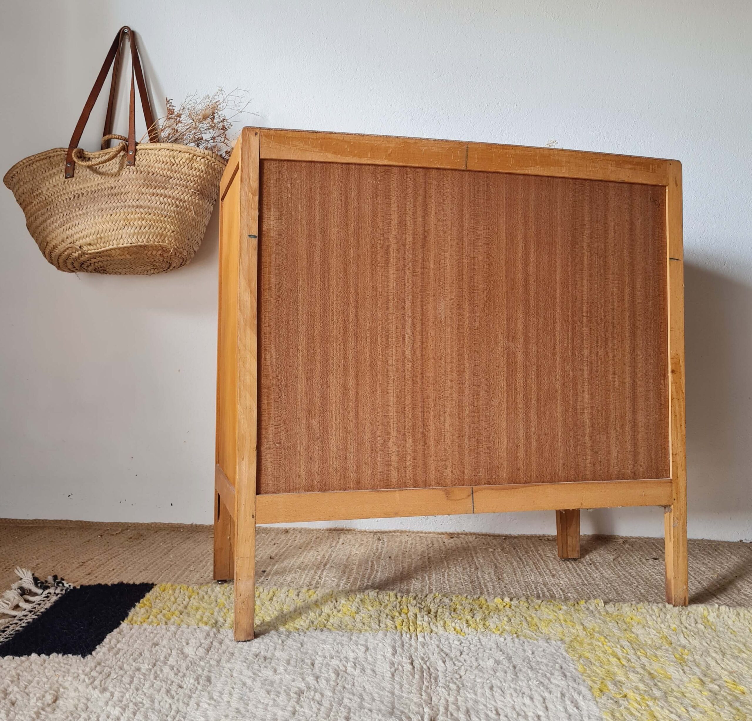 Vue de l'arrière sain en contreplaqué d'une commode vintage en bois clair.
