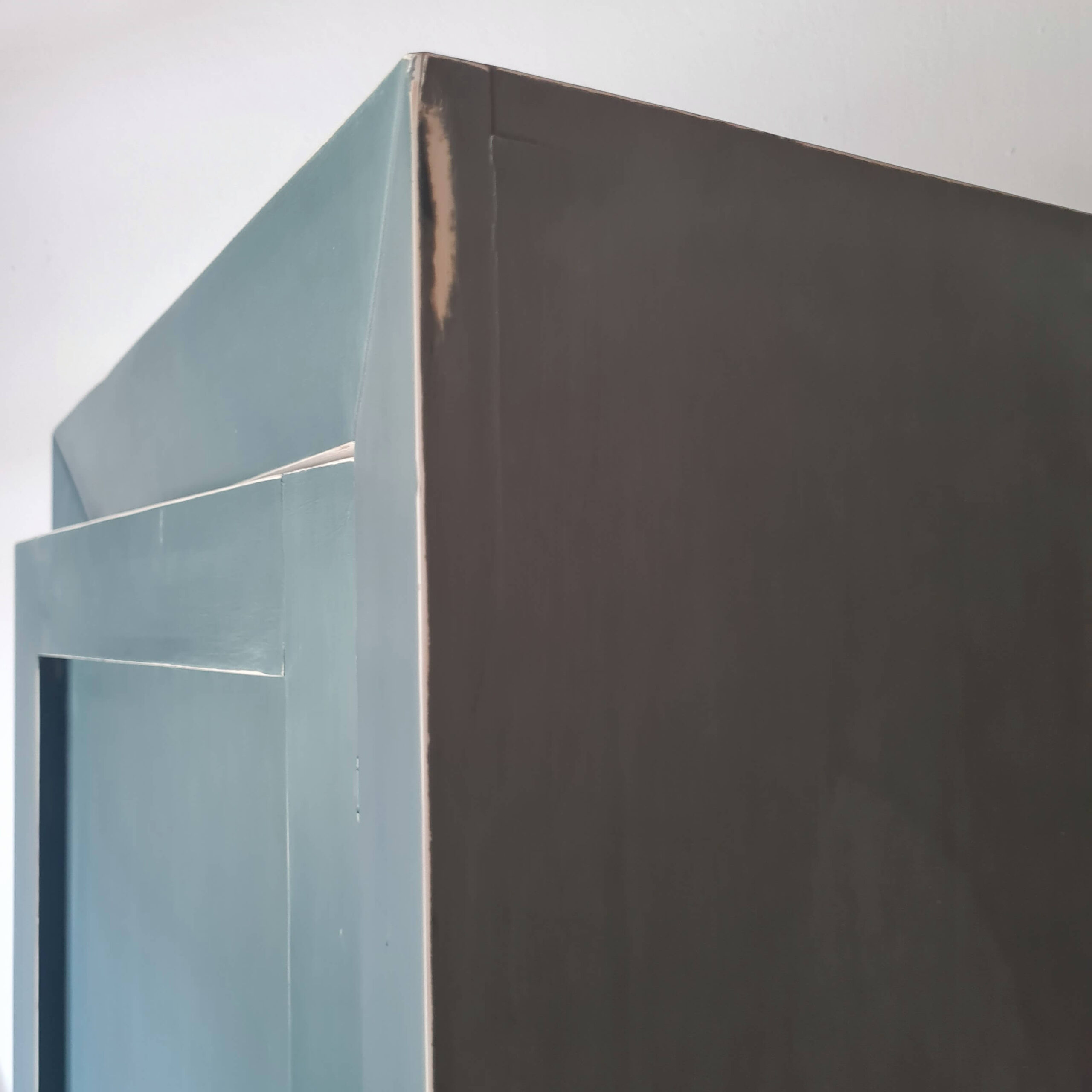 Détail de la finition et de la texture de la peinture sur le côté d'une armoire artisanale bleue