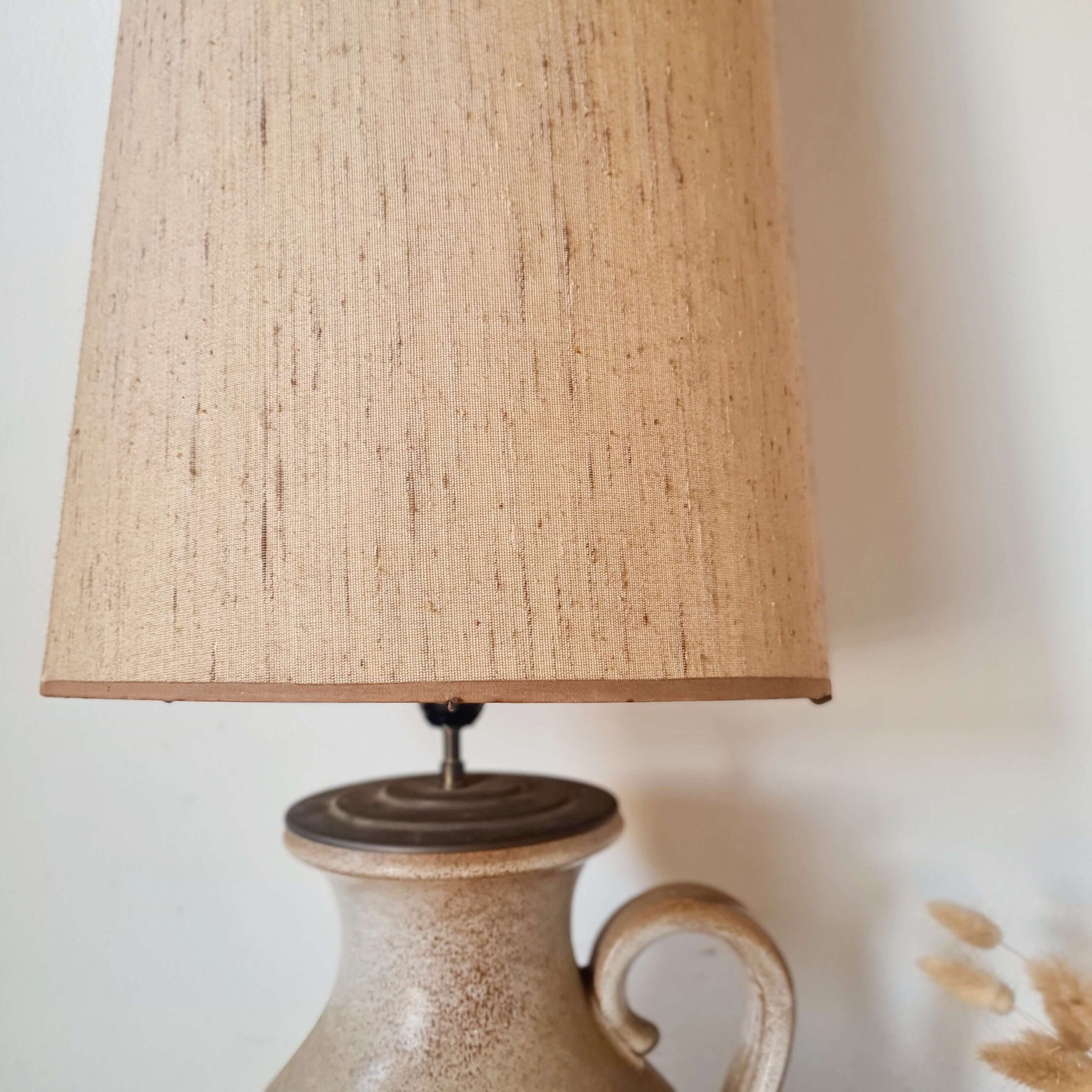 Zoom sur la bordure supérieure de l'abat-jour en tissu beige, finition soignée.