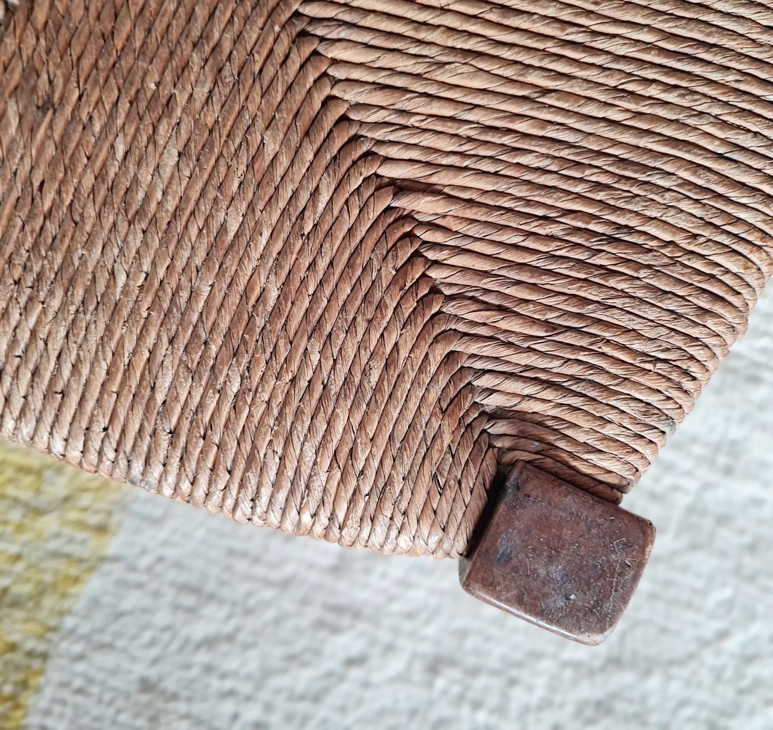 Gros plan détaillé du tressage en paille d'une assise de tabouret rétro.