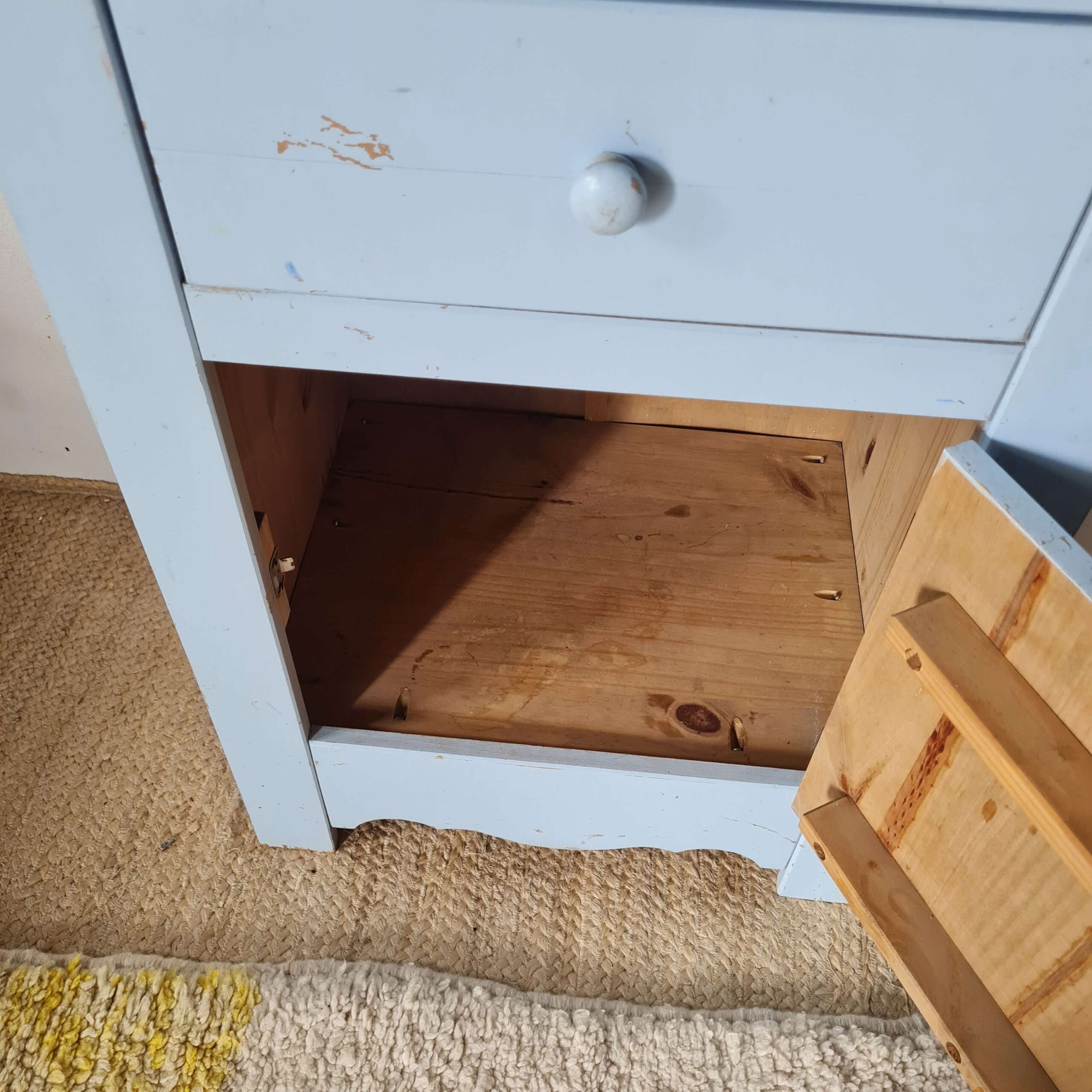 Gros plan sur le fond en bois naturel à l'intérieur du meuble d'appoint vintage.