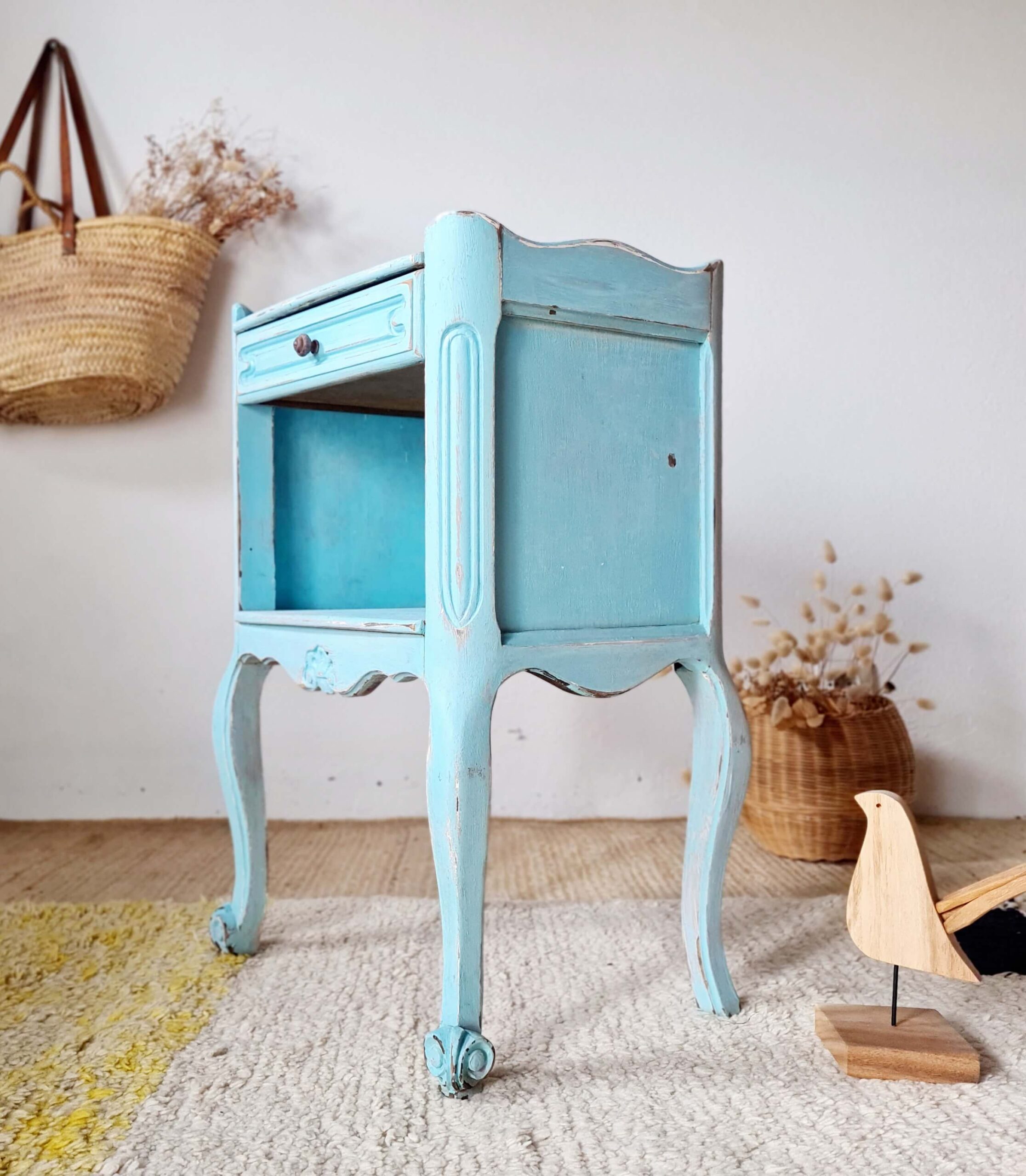 Vue de profil d'un petit meuble de rangement bleu effet vieilli style Shabby Chic.