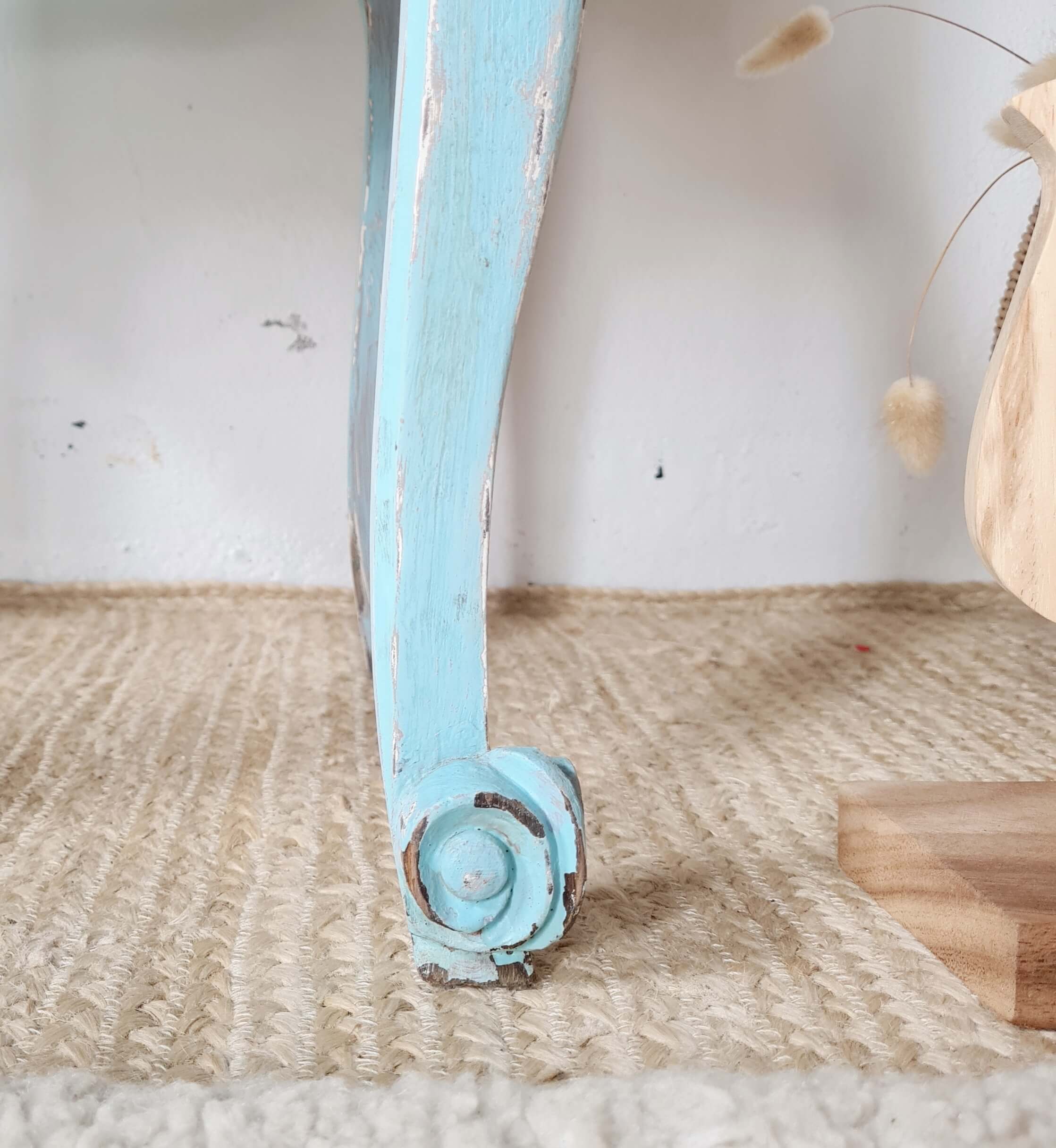 Détail du pied galbé style biche avec peinture patinée et usée d'un chevet bohème.