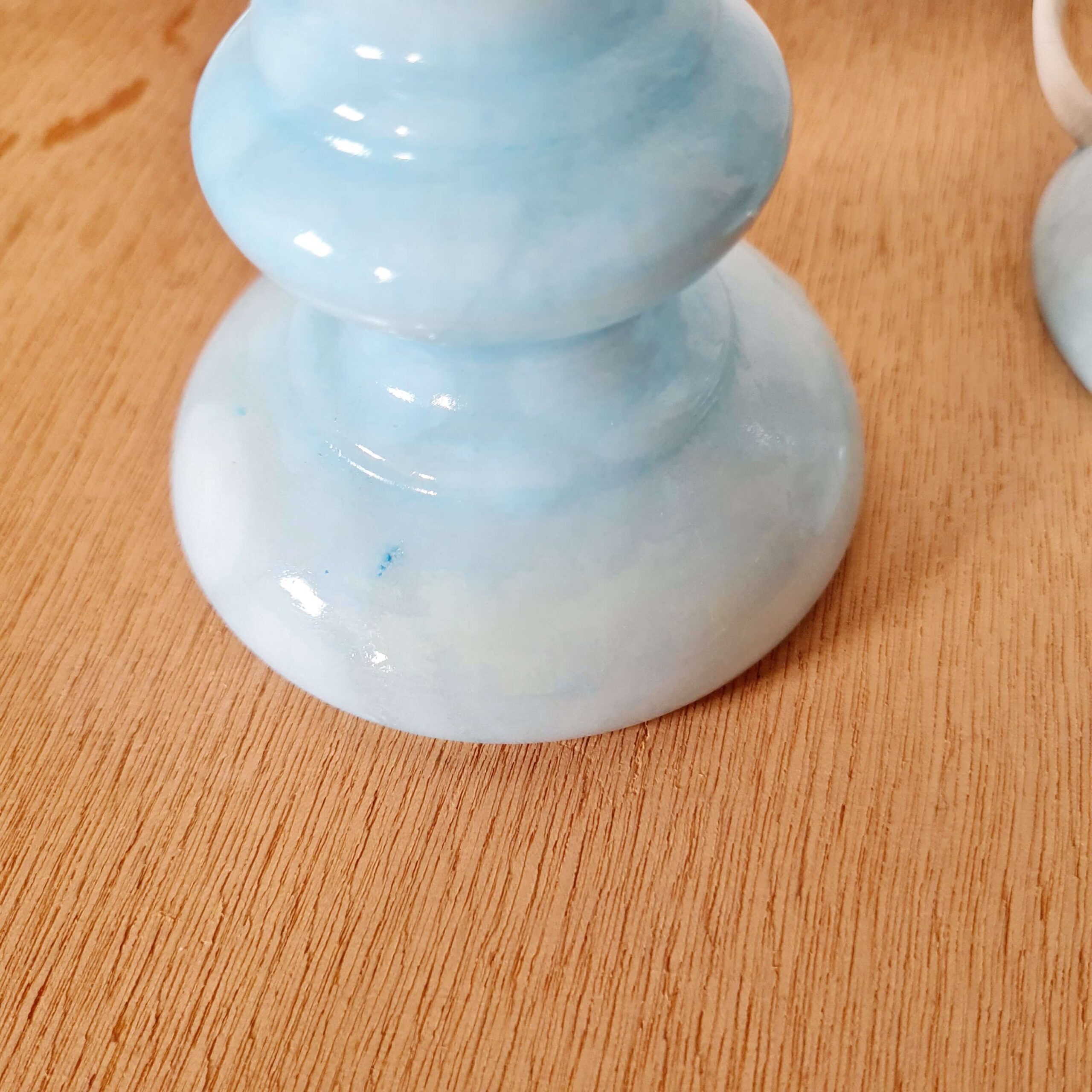 Zoom sur les reflets marbrés de la base arrondie en opaline bleu ciel du luminaire