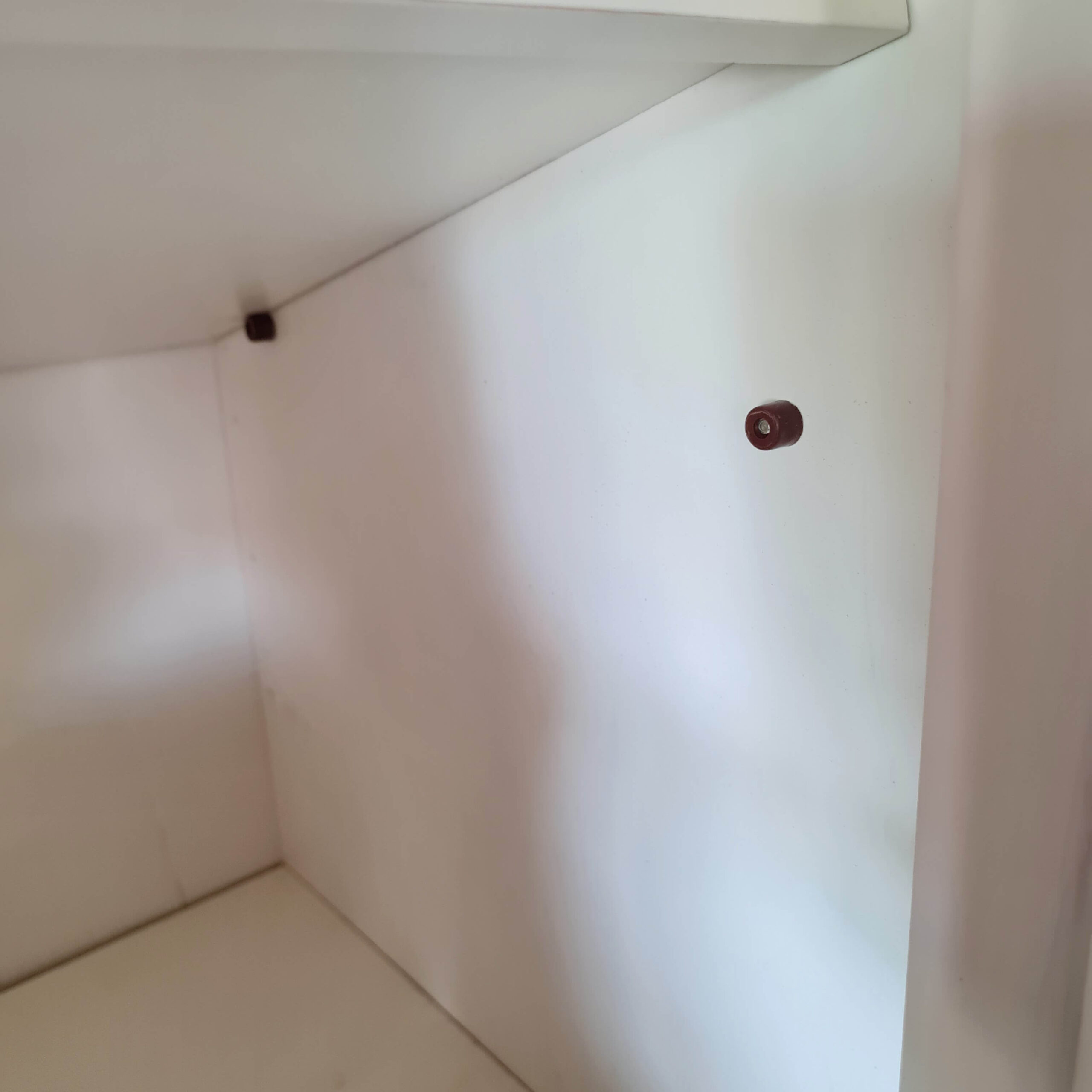 Gros plan sur un taquet de support d'étagère à l'intérieur d'une armoire ancienne