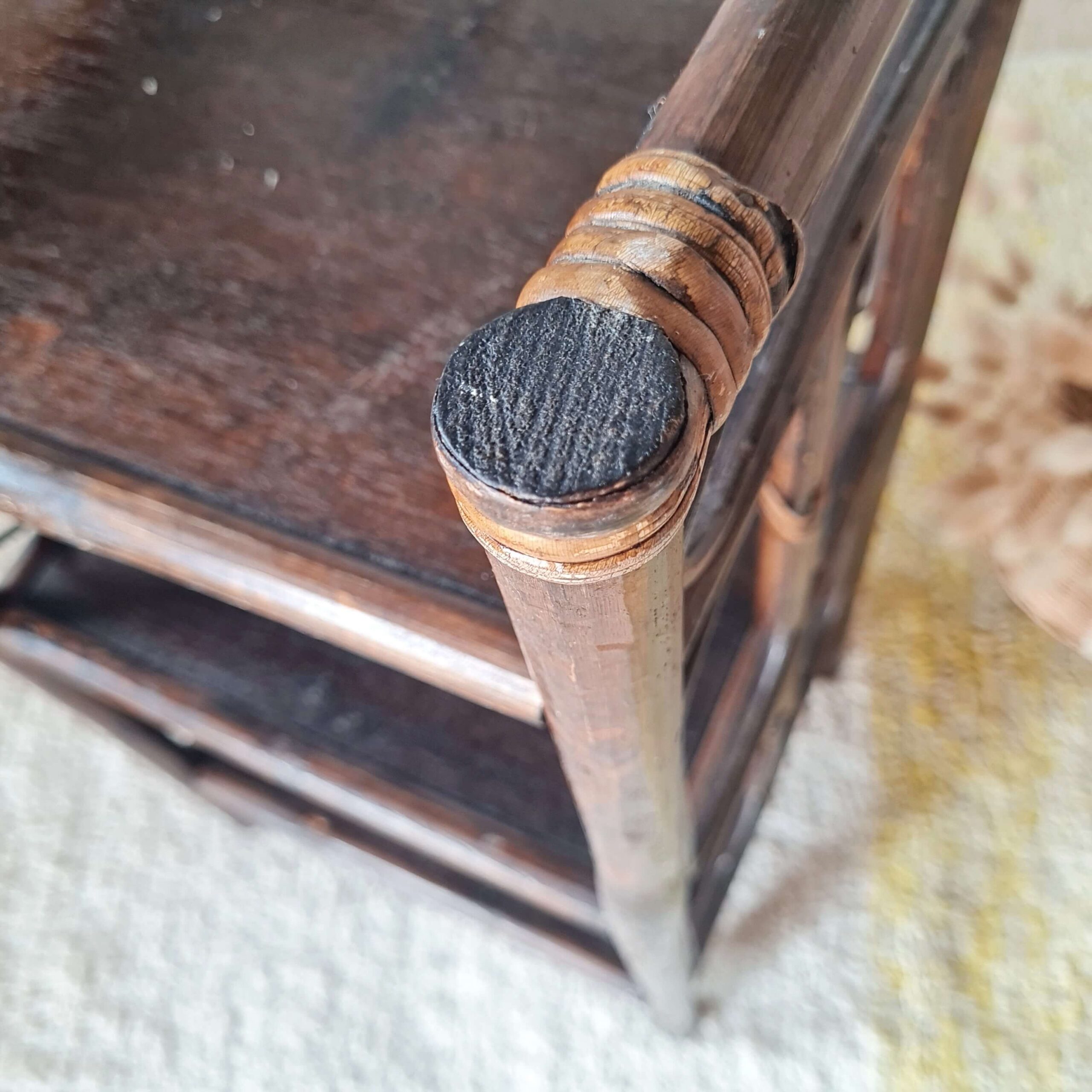 Zoom sur le détail de la finition et du tressage de l'angle supérieur d'un meuble en rotin.