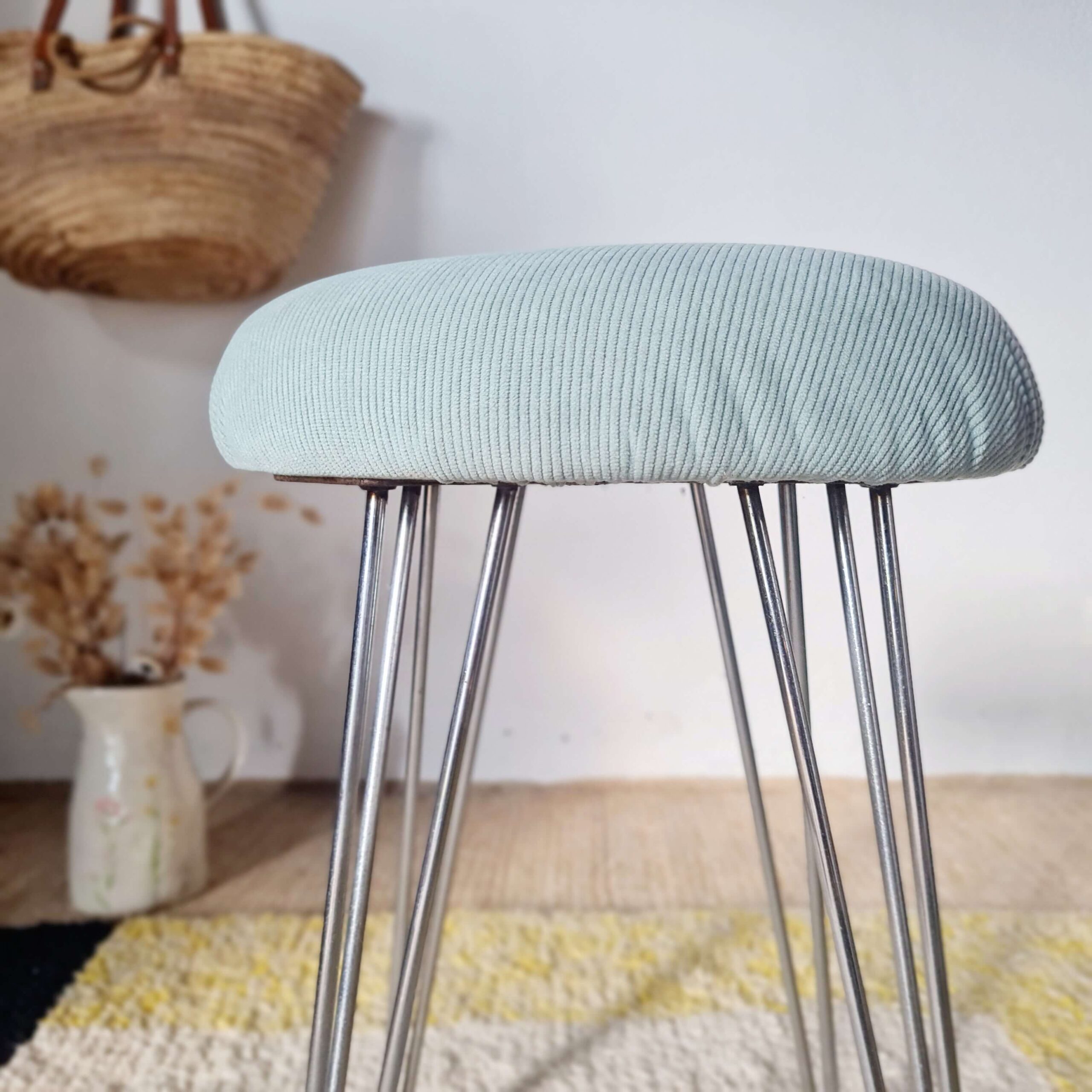 Vue de profil du tabouret rétro mettant en valeur le coussin rond en velours côtelé et ses pieds fins.