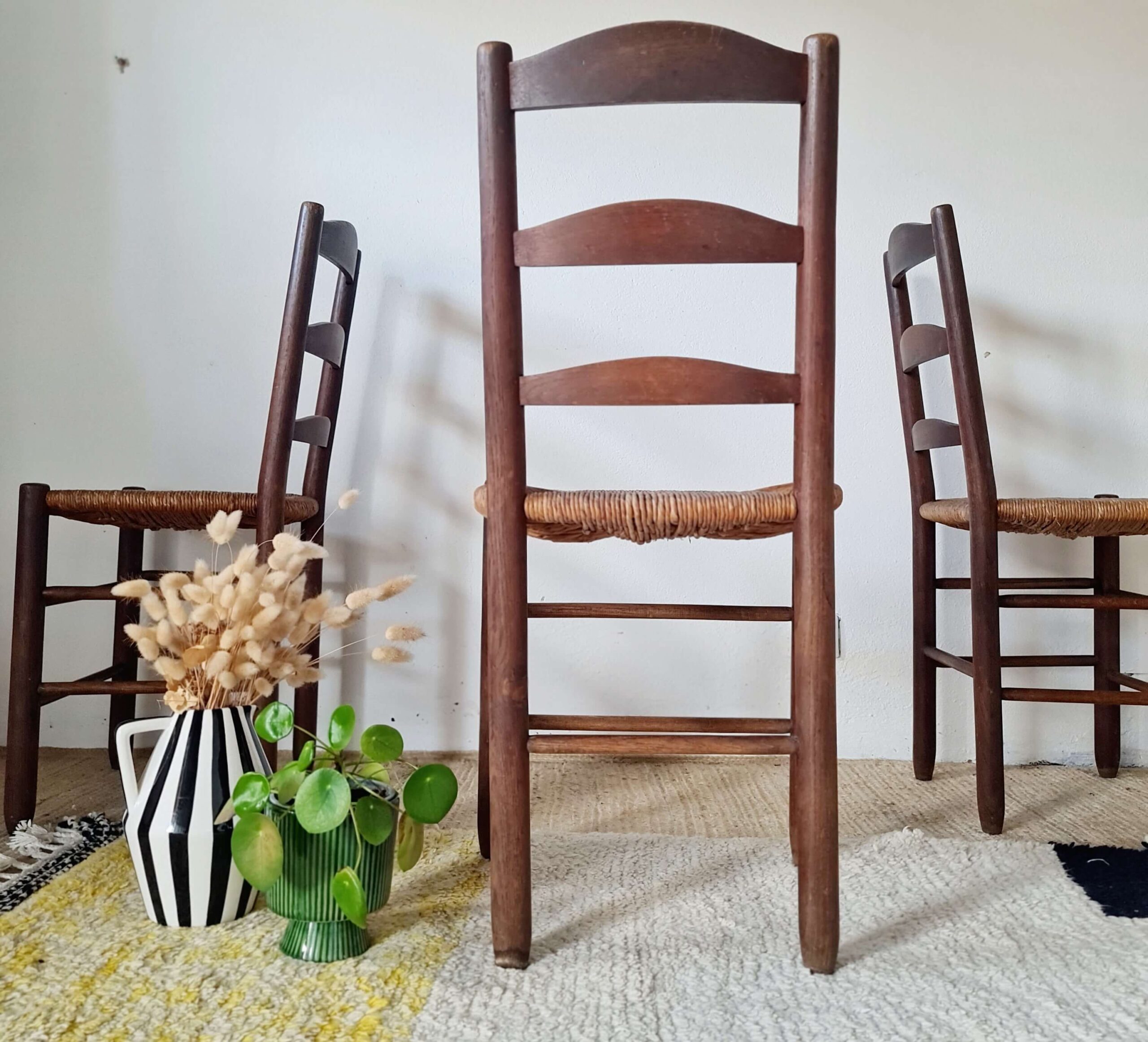 Vue de dos d'une chaise de campagne ancienne en bois et assise en paille - look brutaliste