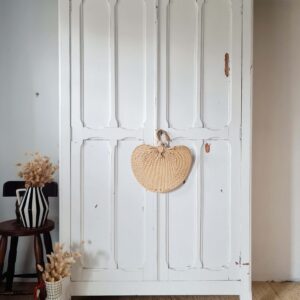 Photographie complète de l'armoire parisienne blanche, portes fermées, centrée dans un décor bohème avec un tapis en laine