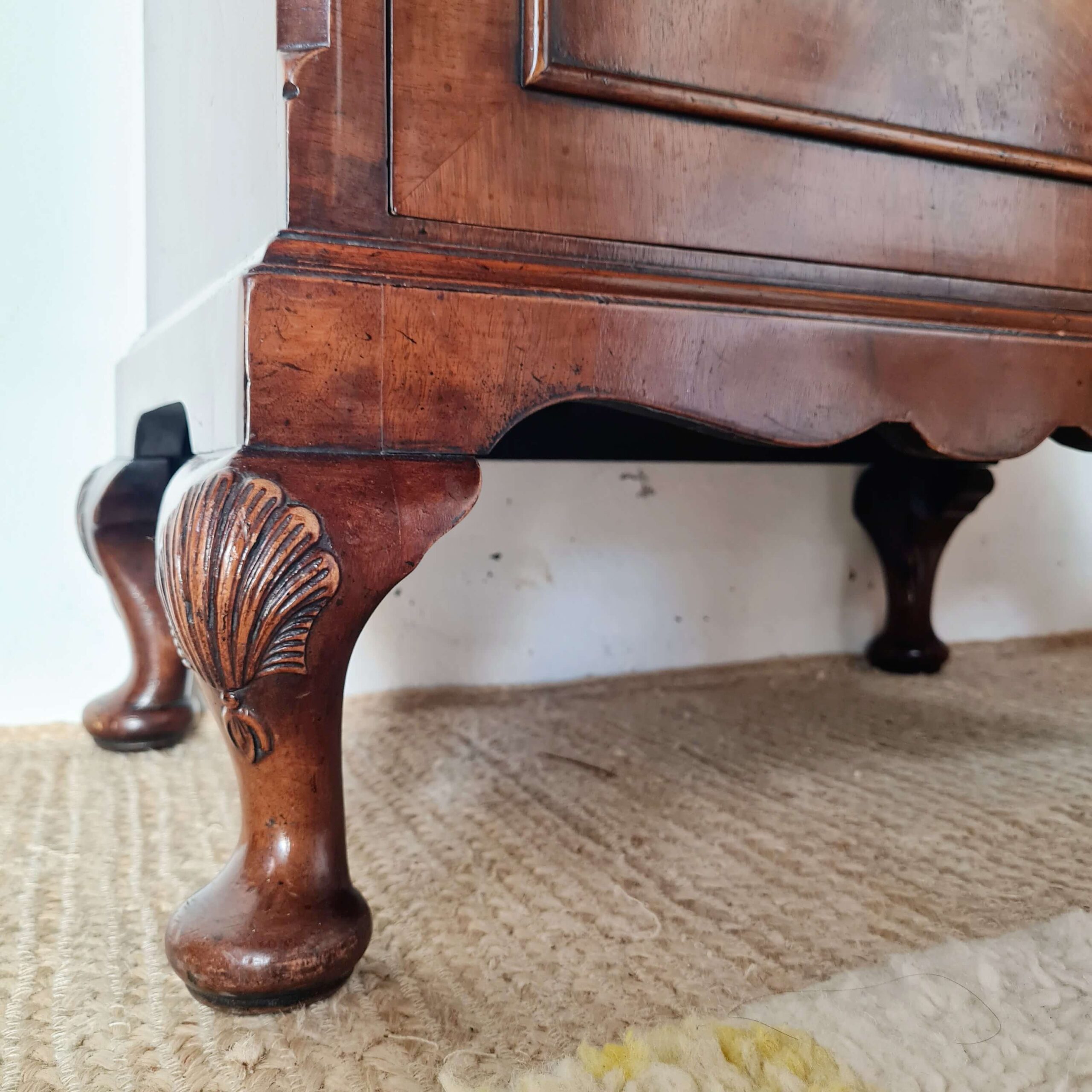 Détail des pieds sculptés ball and claw et motif coquillage d'un meuble ancien 1930