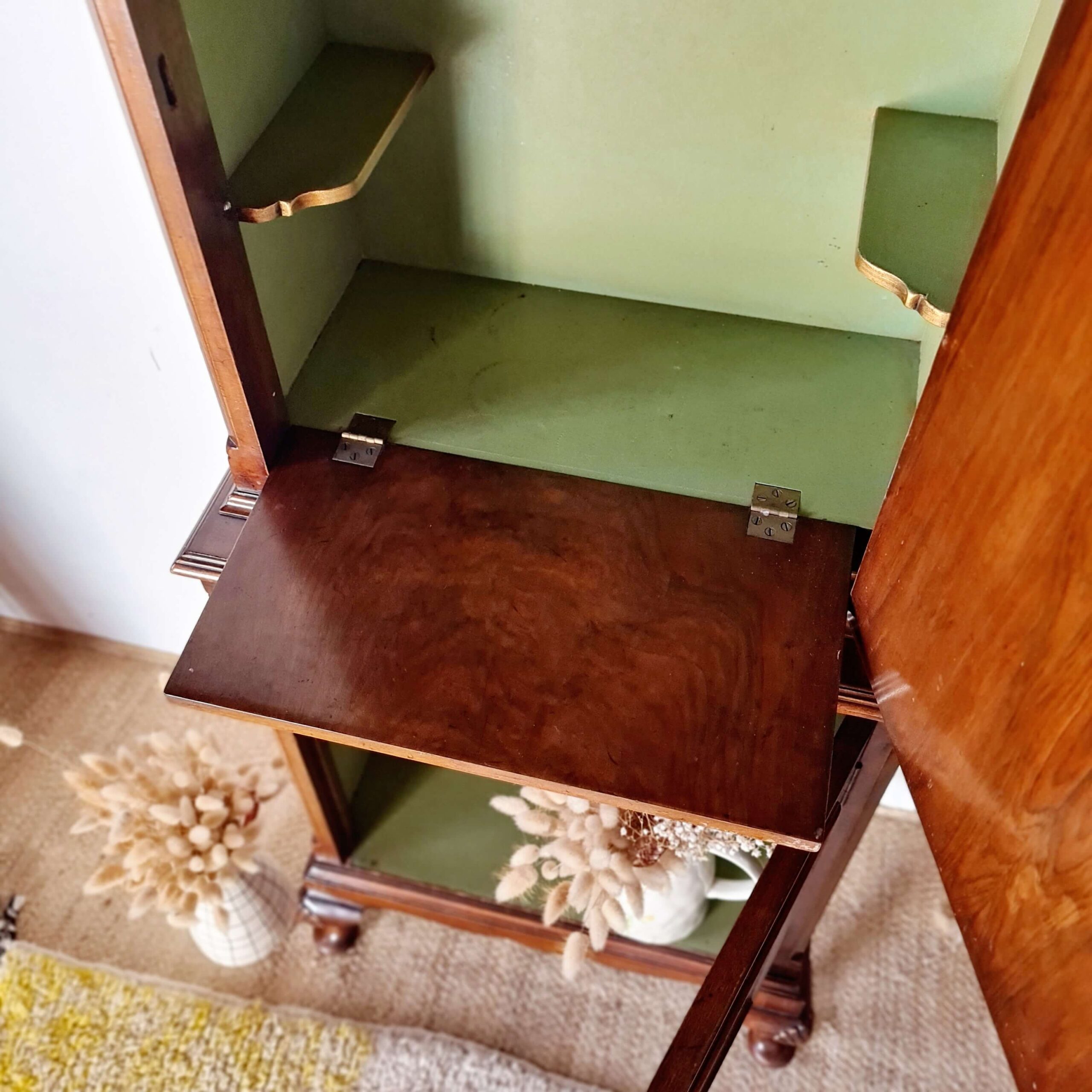 Intérieur vert tendre et doré d'un meuble de rangement ancien de 1930