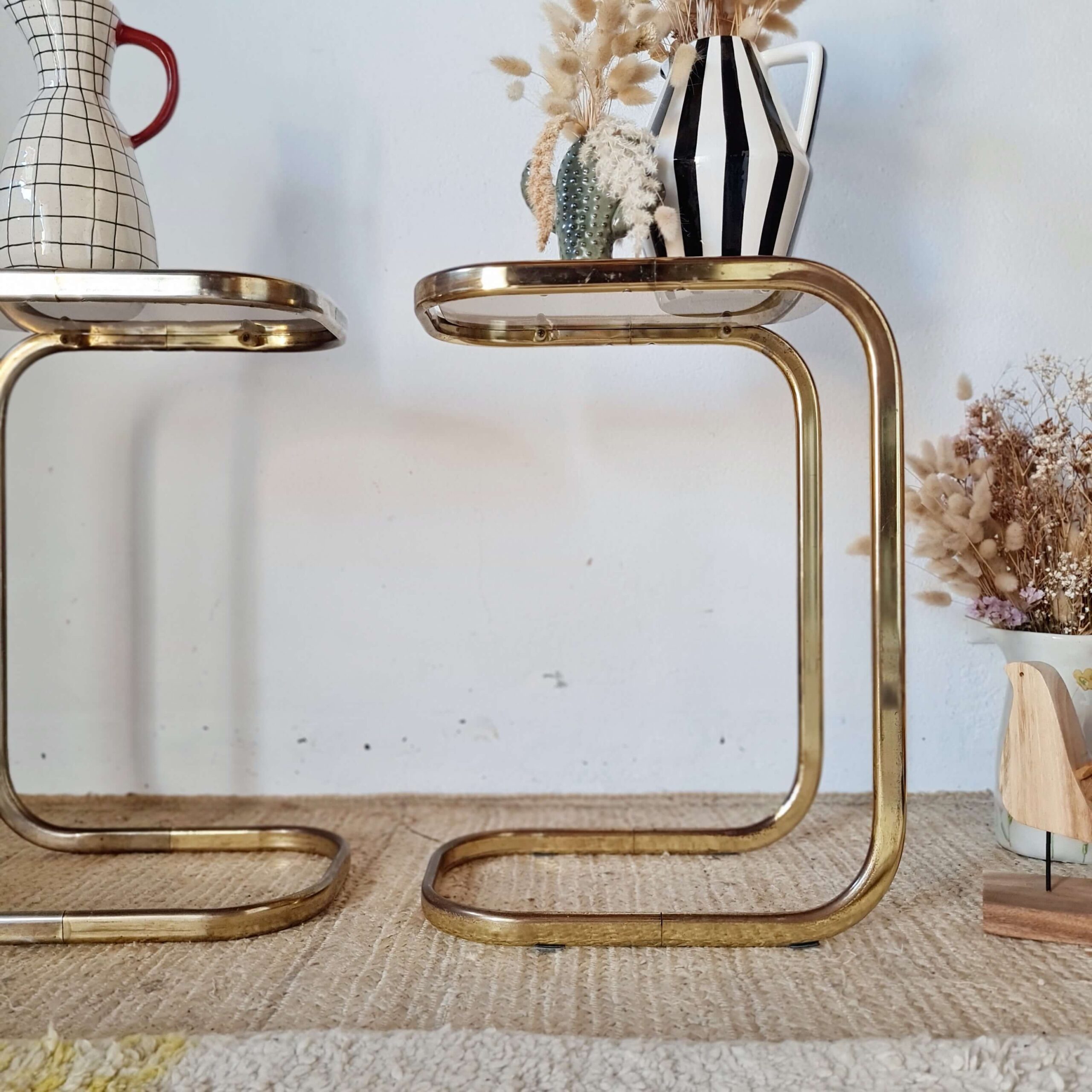 Vue de profil ravissant pour cette paire de tables en métal doré et plateau verre fumé vintage des années 70