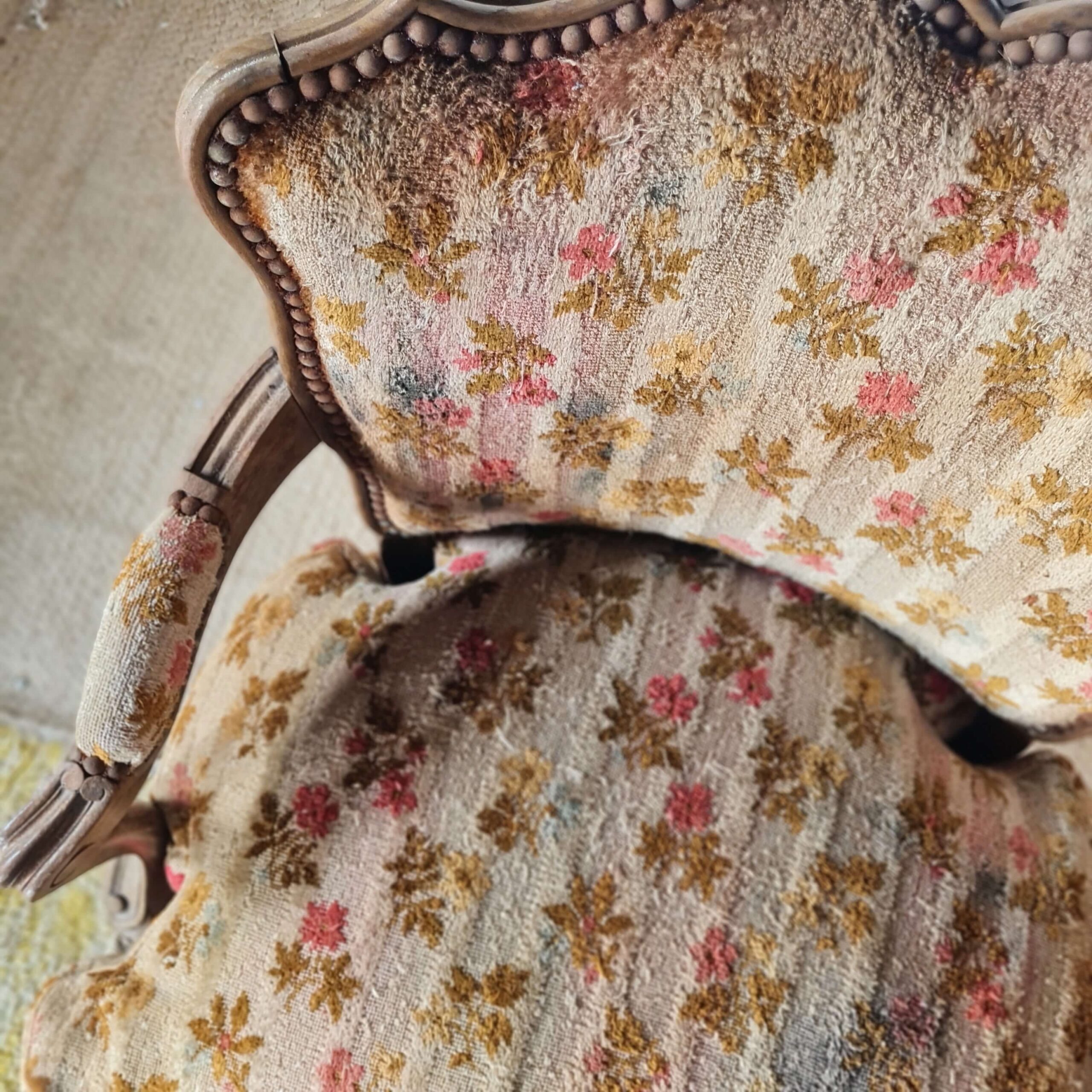 Vue de dessus sur les motifs fleuris de cet ancien fauteuil cabriolet vintage