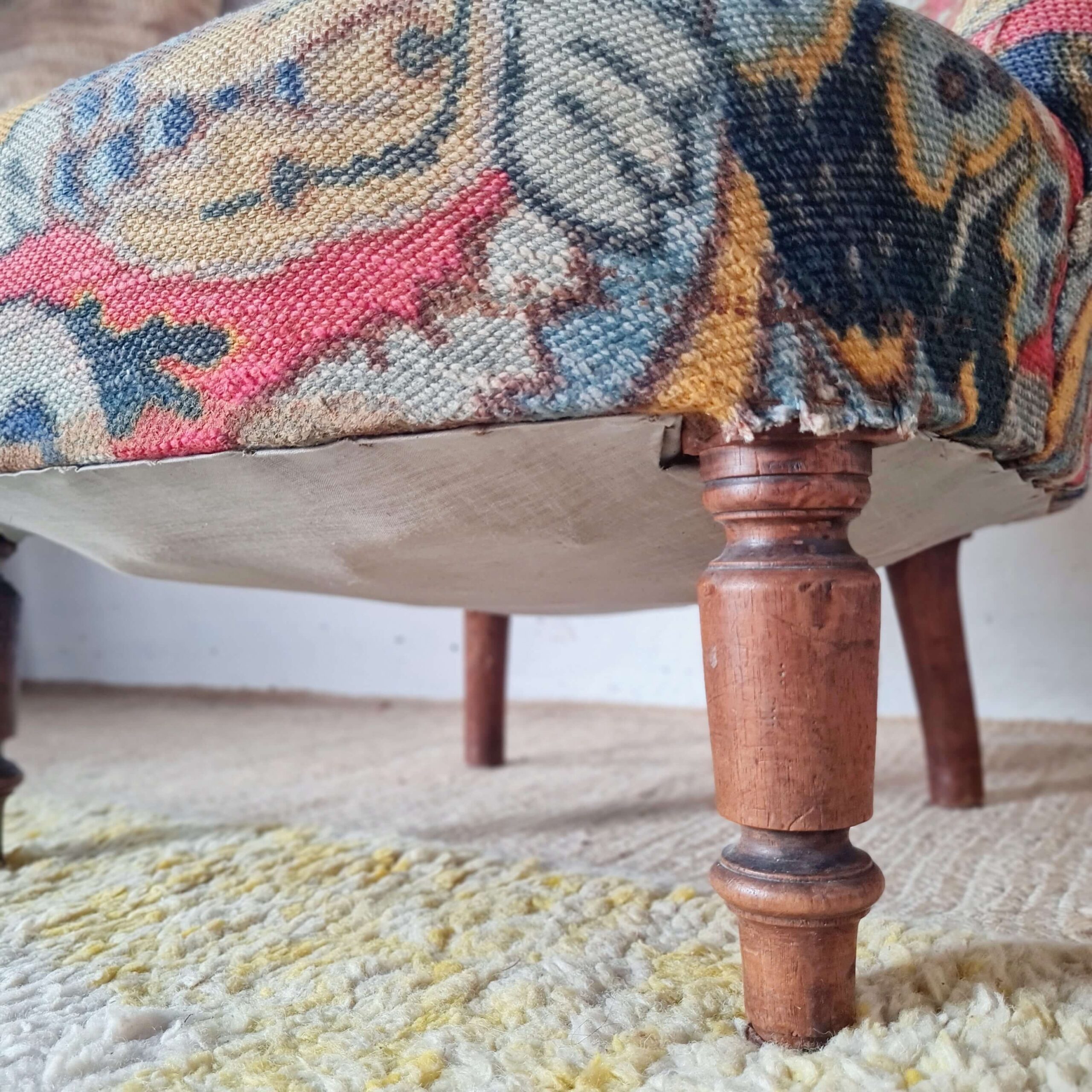 gros plan sur un pied en bois tourné d'un fauteuil crapaud ancien