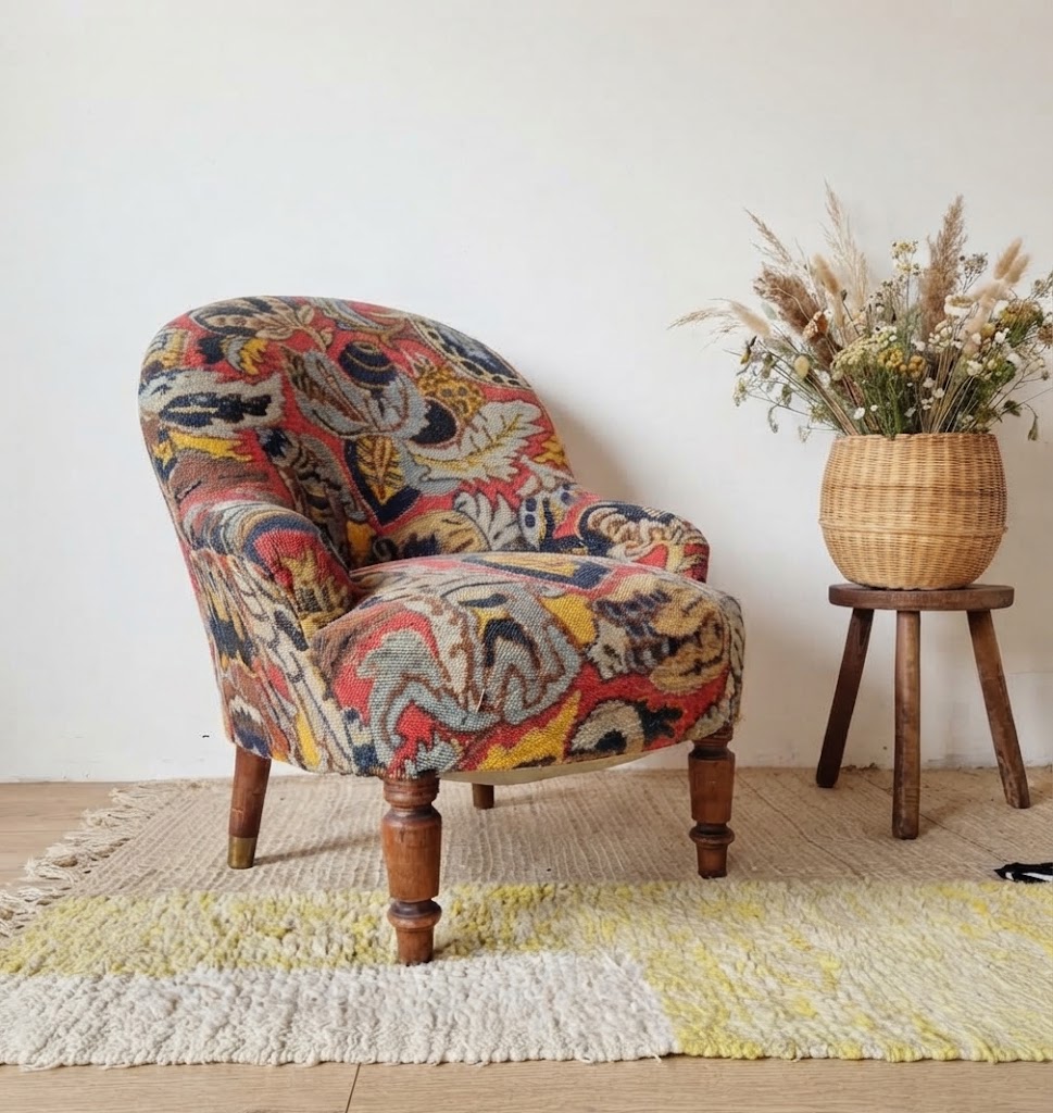 Fauteuil crapaud vintage vu de dos, mettant en valeur son dossier arrondi recouvert d'un tissu fleuri coloré et chaleureux.