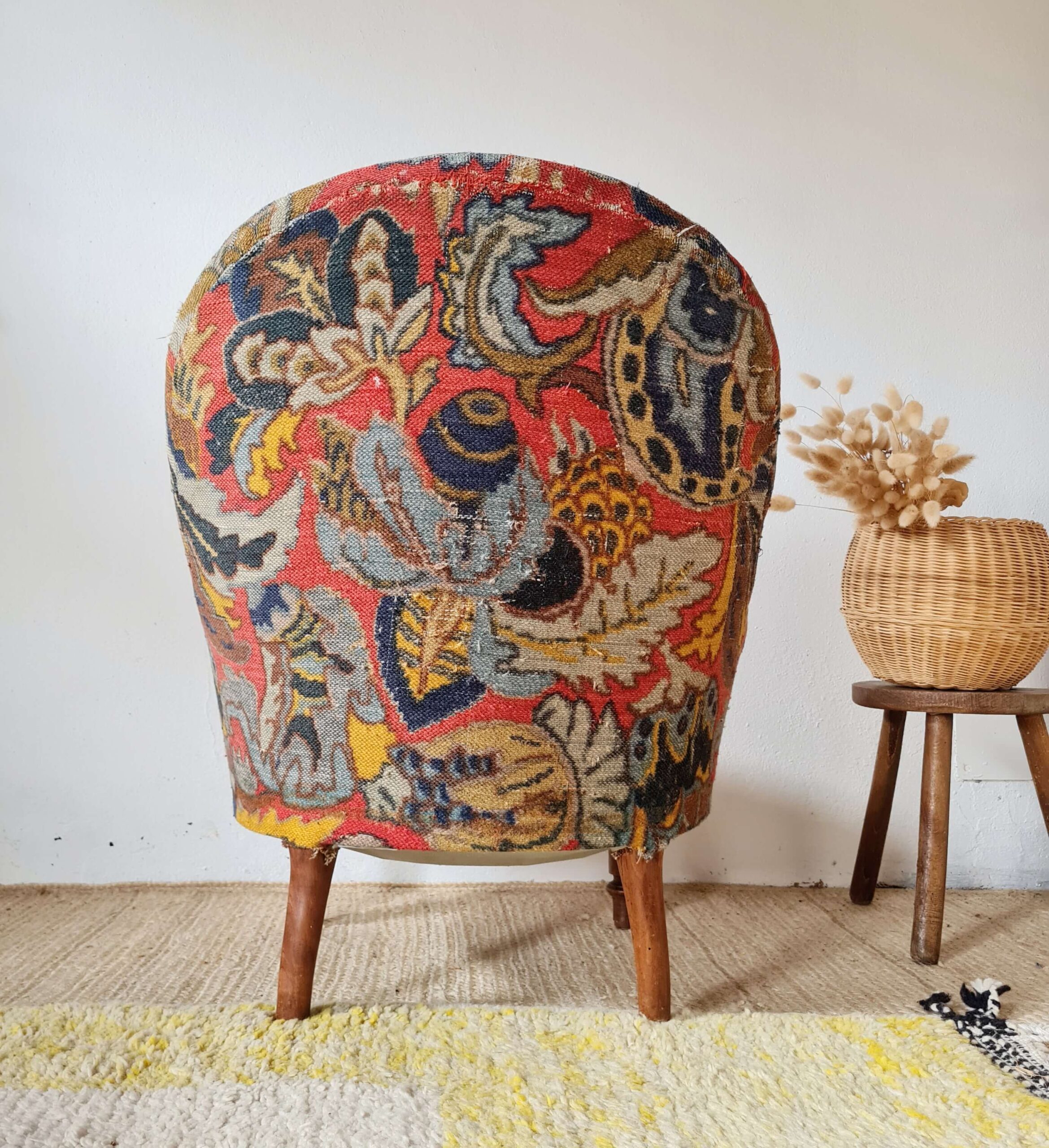 Vue de dos d'un fauteuil crapaud ancien paré de son tissu fleuri
