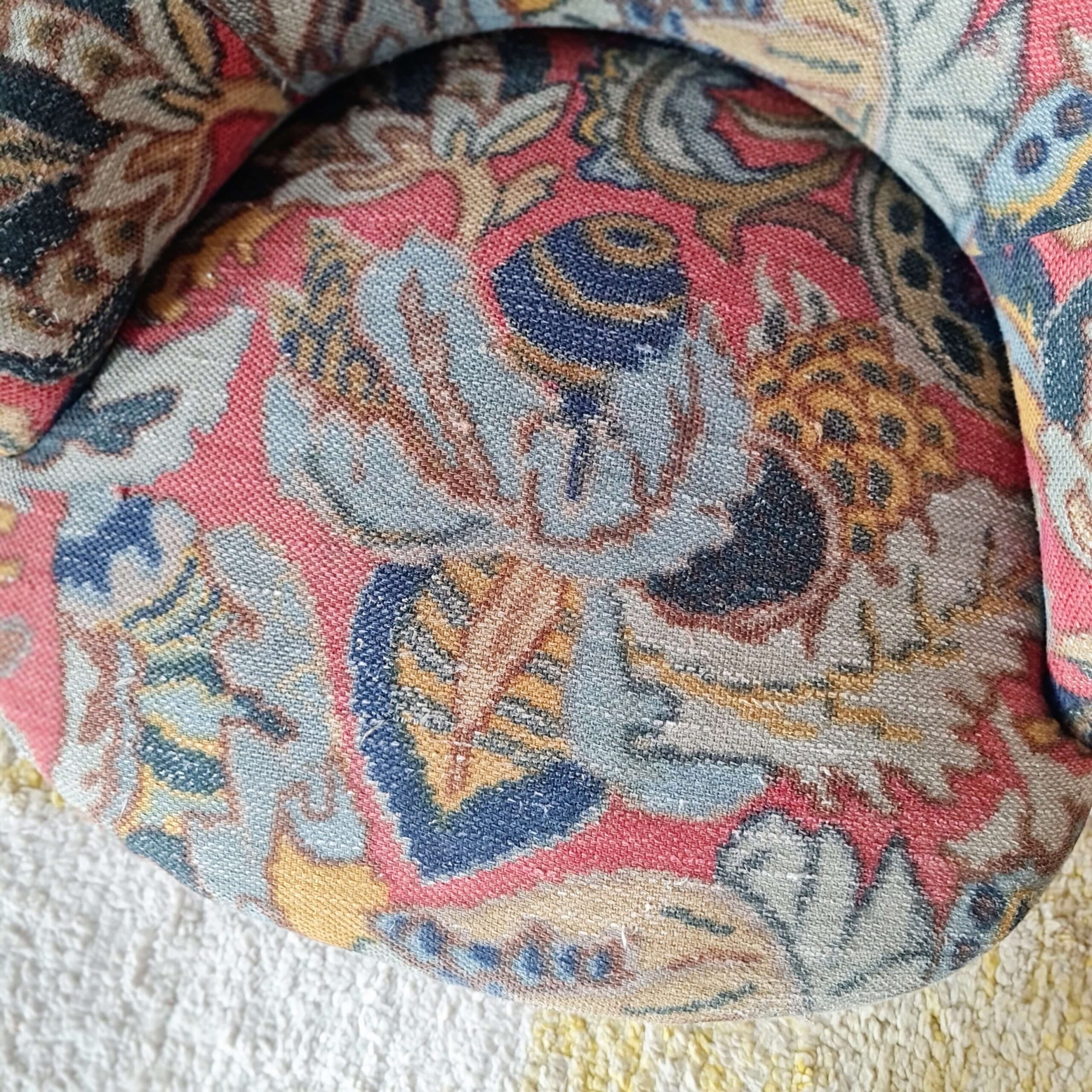 Vue du dessus de l'assise d'un fauteuil crapaud ancien avec motifs colorés