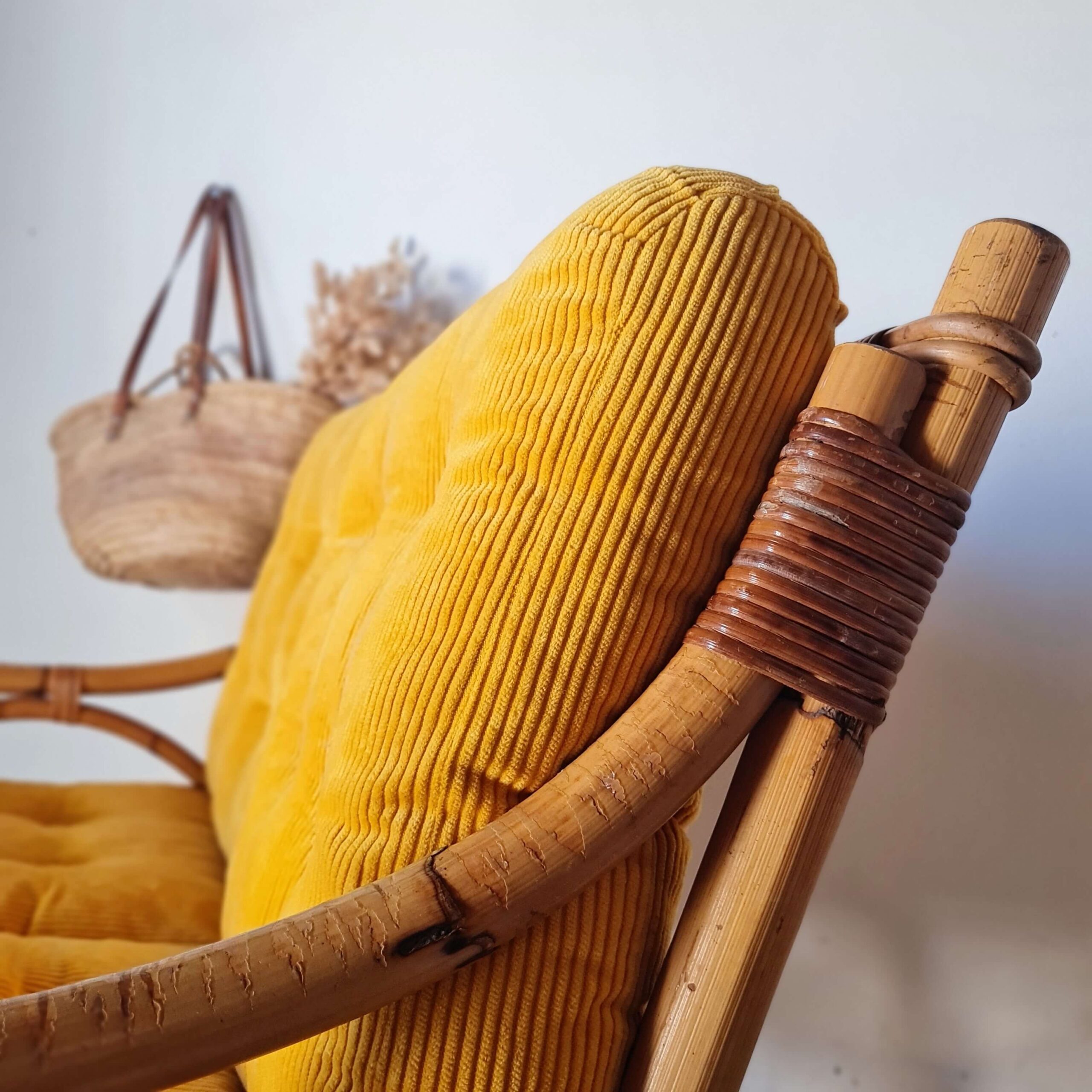 Banquette en rotin avec ses coussins en velours jaune