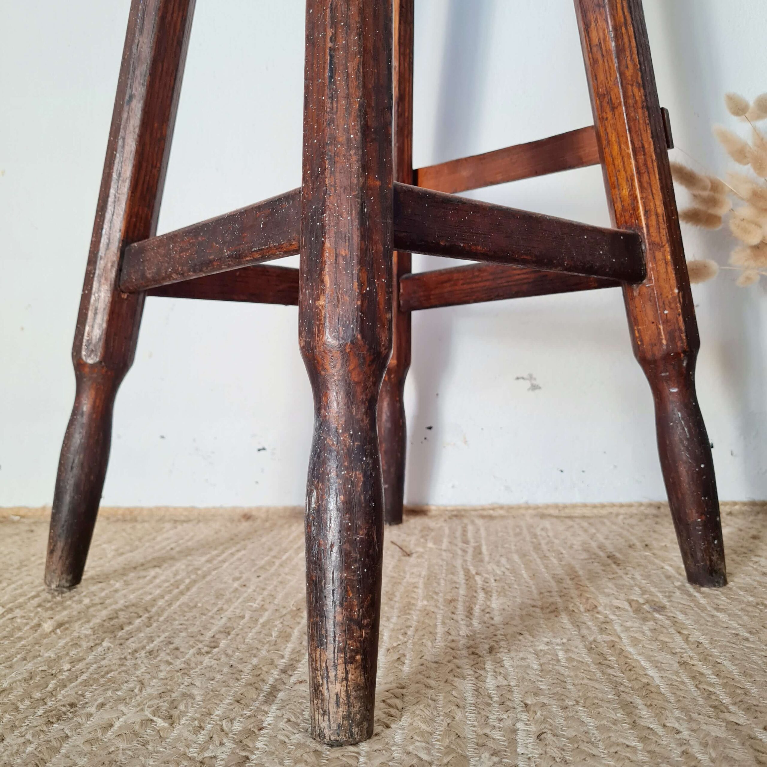 Structure solide et robuste pour cet ancien tabouret haut d'atelier en bois