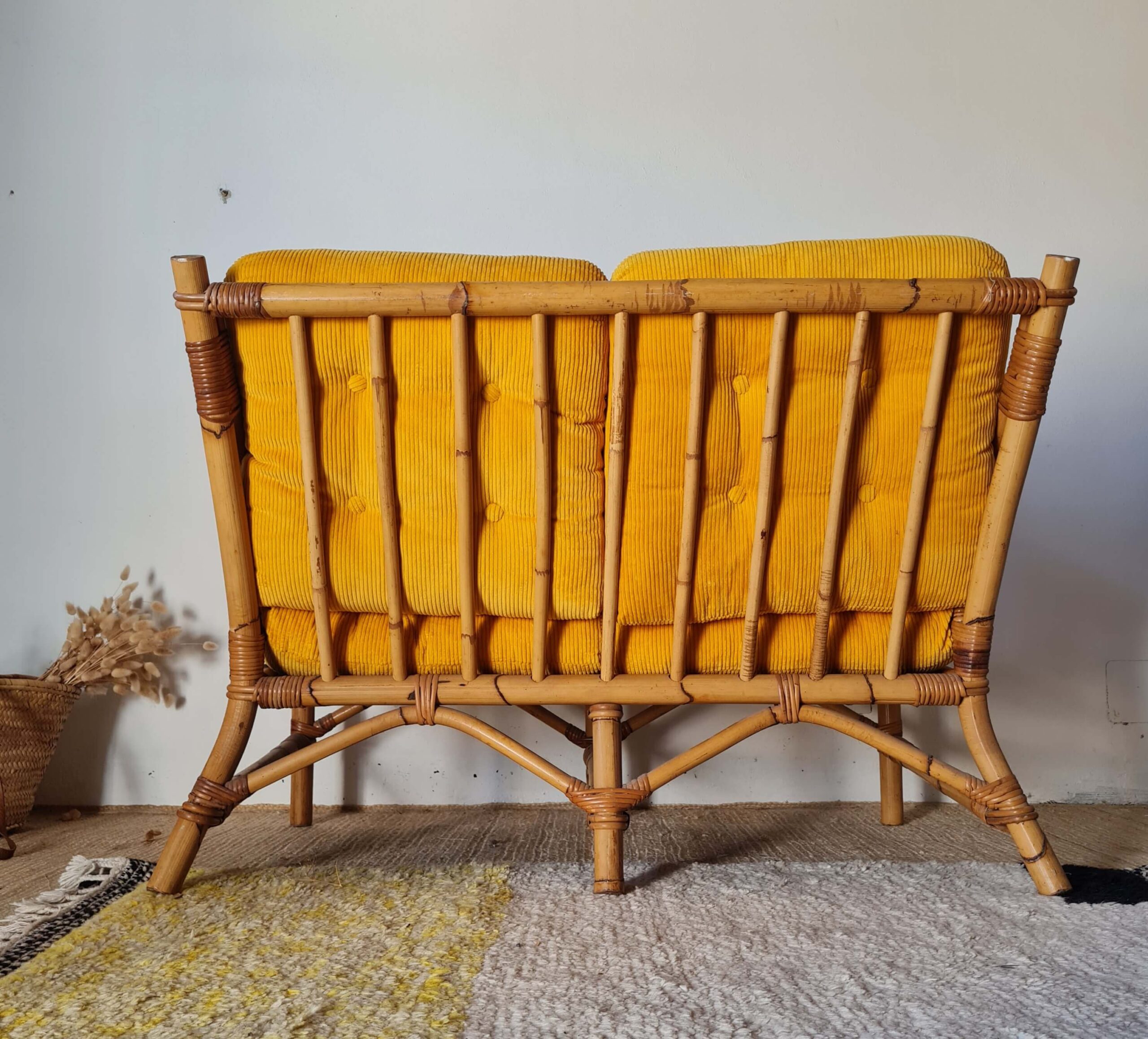 Vue de dos d'une banquette ancienne en rotin