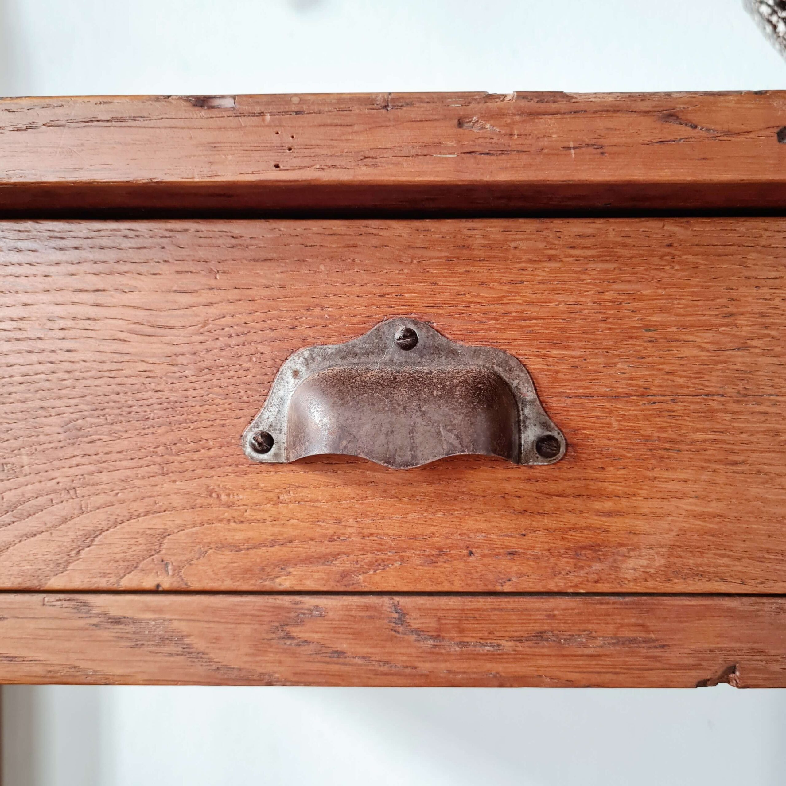 Zoom sur la poignée coquille d'origine patinée pour cette table en bois ancienne