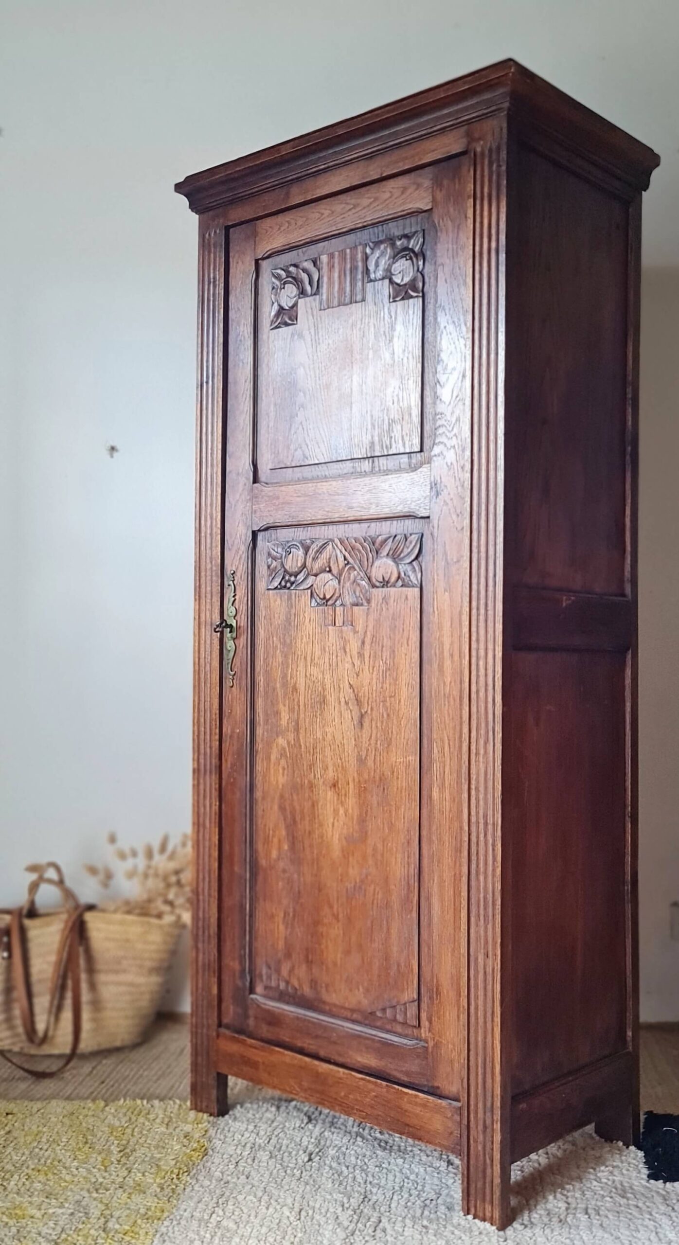 Vue de trois-quarts d'une armoire bonnetière 1 porte en chêne sculpté