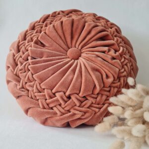 Vue du dessus du coussin rond vintage plissé en velours rose poudré