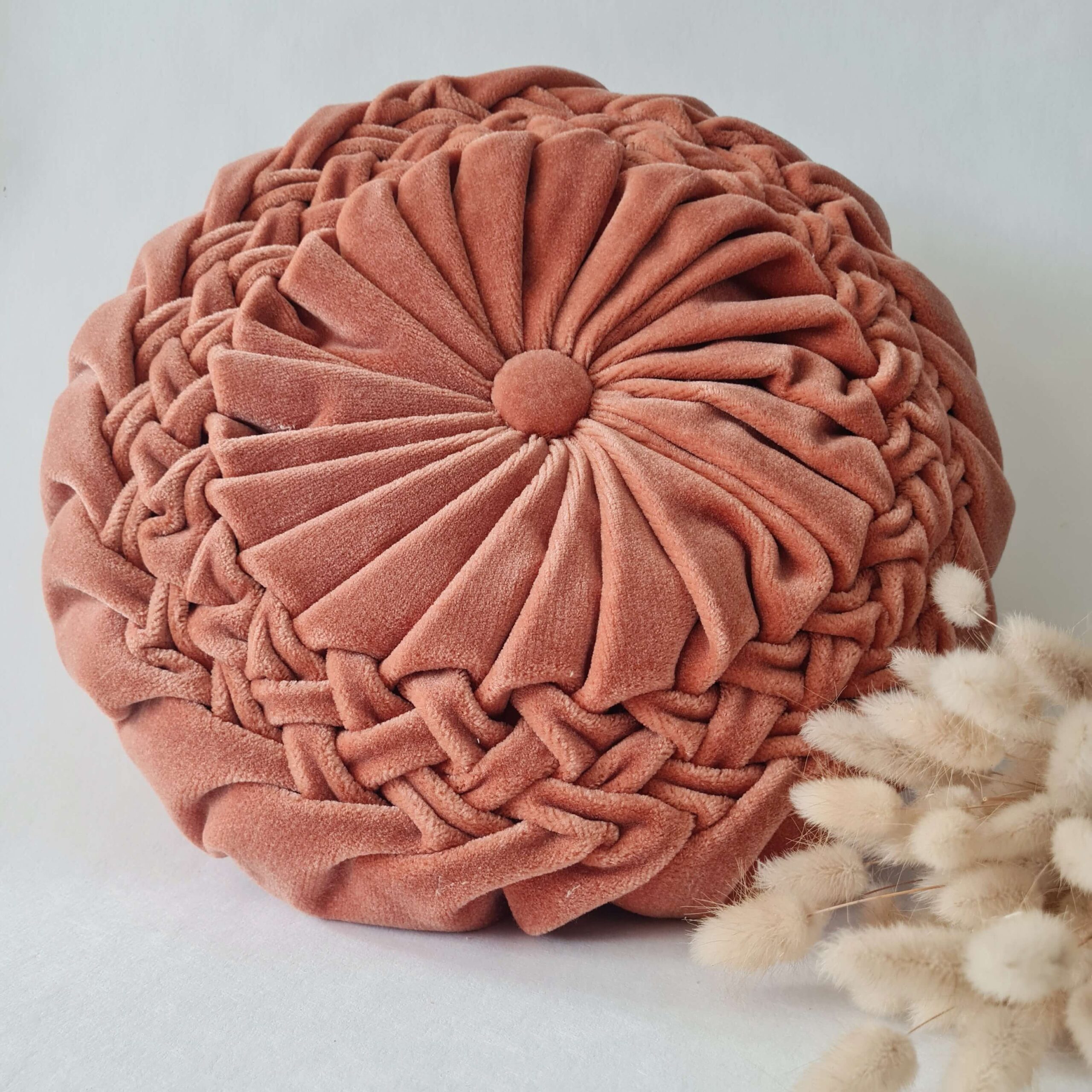 Vue du dessus du coussin rond vintage plissé en velours rose poudré