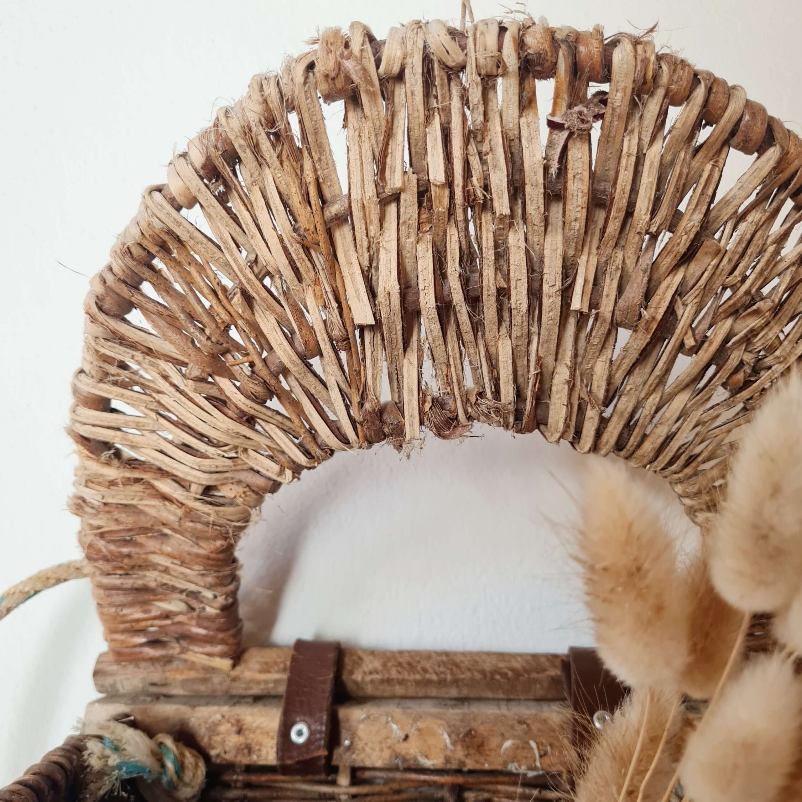 Détail de la charnière en cuir et de la structure en bois à l'intérieur du panier.