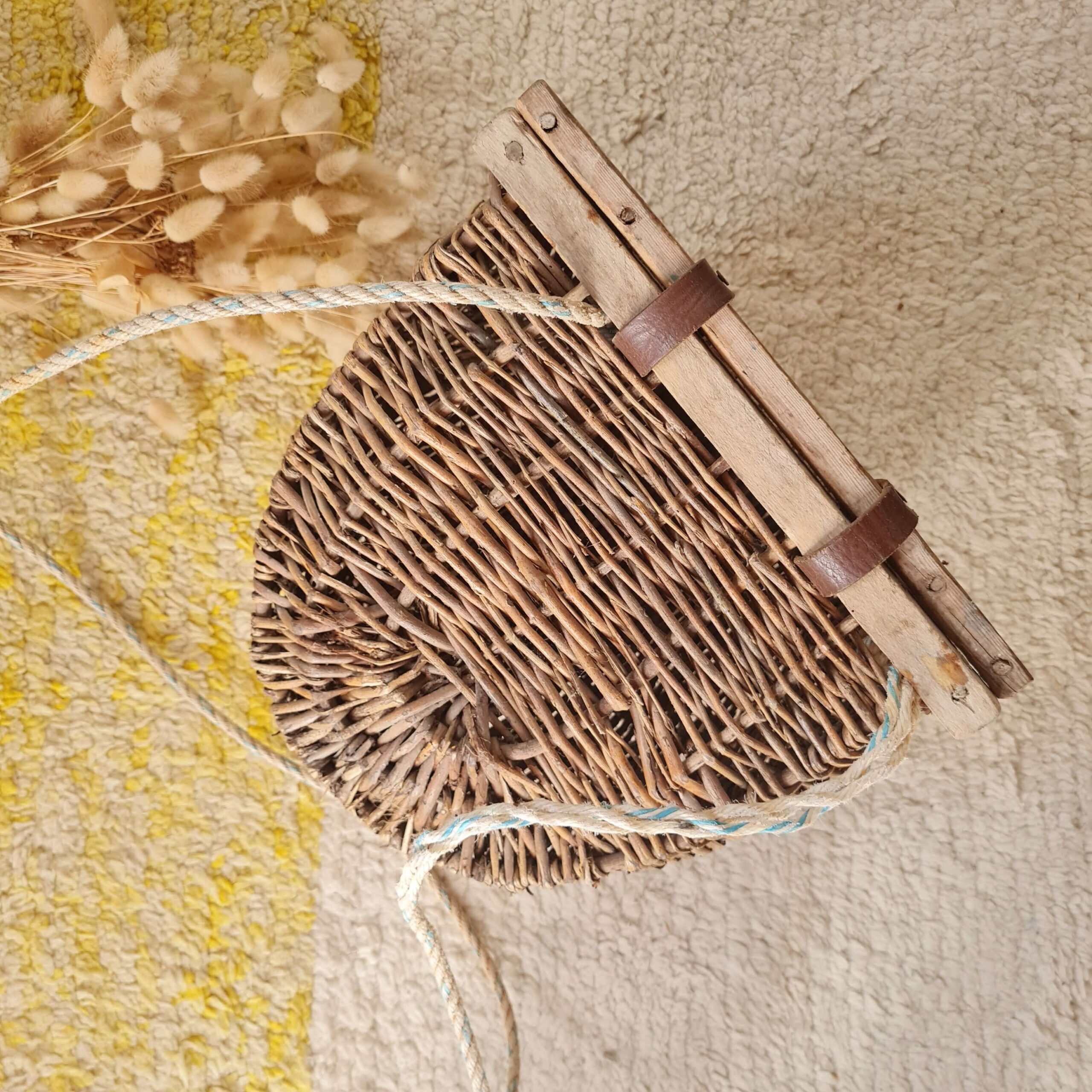 Dos du panier mural montrant le châssis en bois plat et les sangles de cuir.