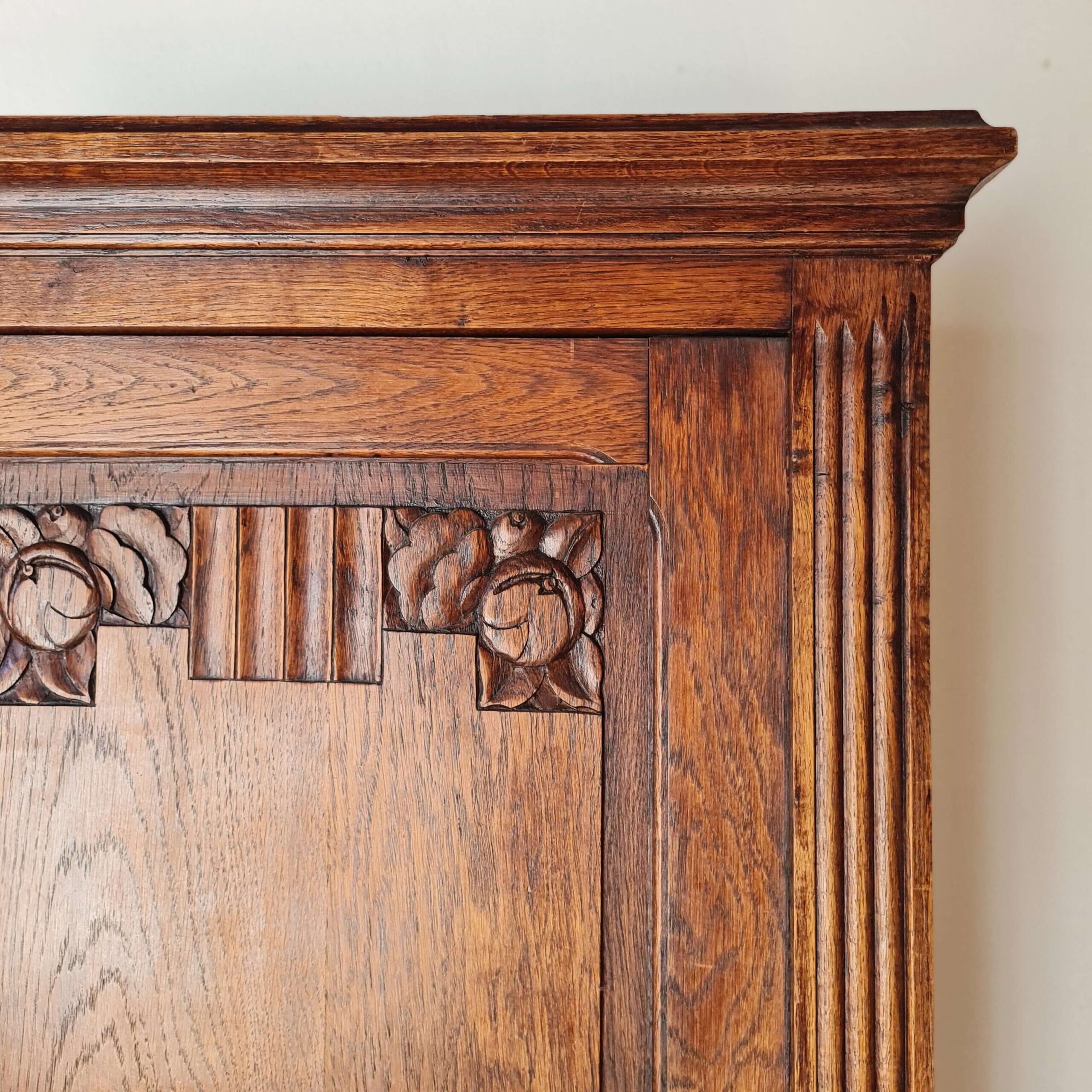 Détail des motifs floraux sculptés sur armoire bonnetière en chêne